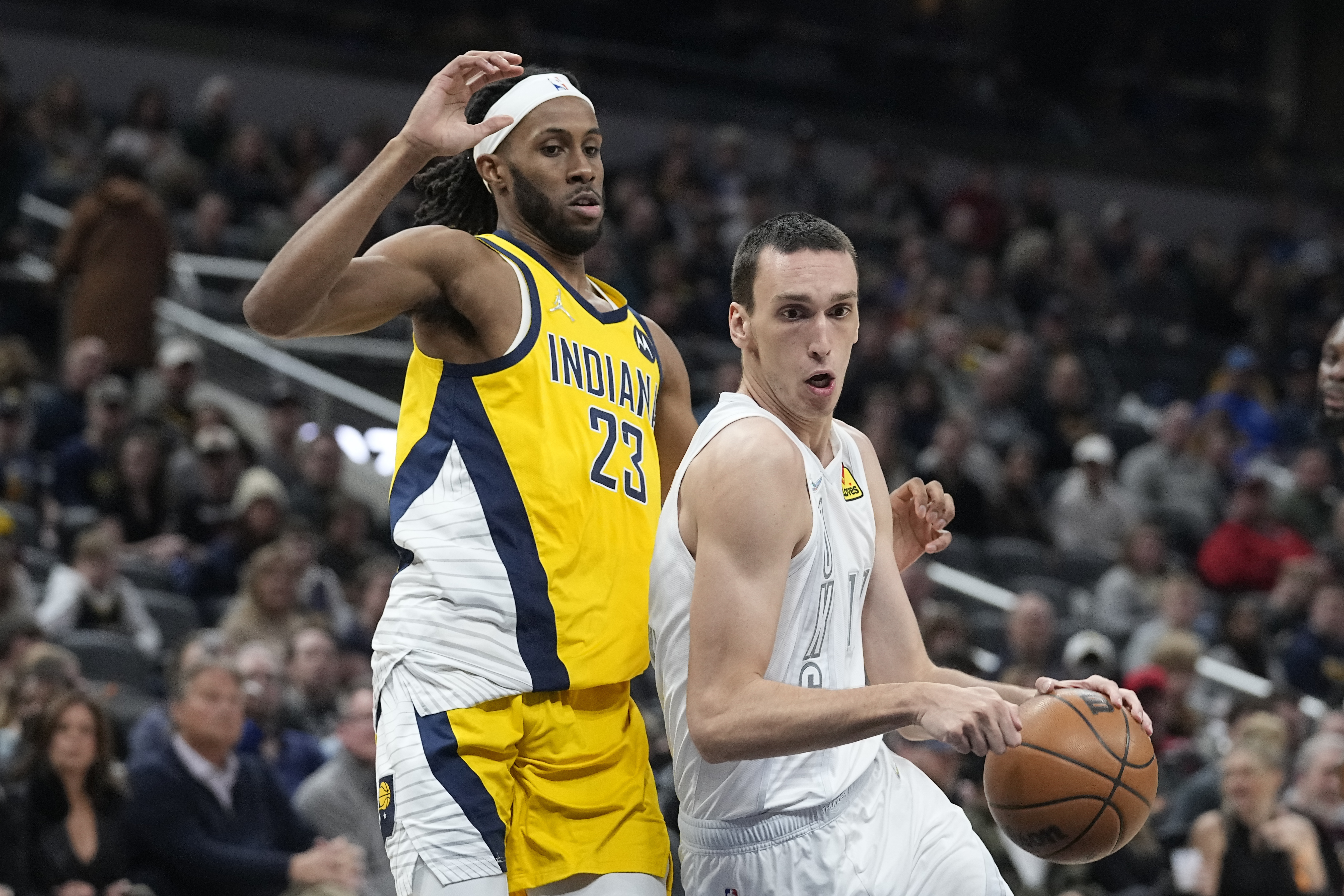 Oklahoma City Thunder's Aleksej Pokusevski drives past Indiana Pacers' Isaiah Jackson (23) during the first half of an NBA basketball game Friday, Feb. 25, 2022, in Indianapolis. (AP Photo/Darron Cummings)