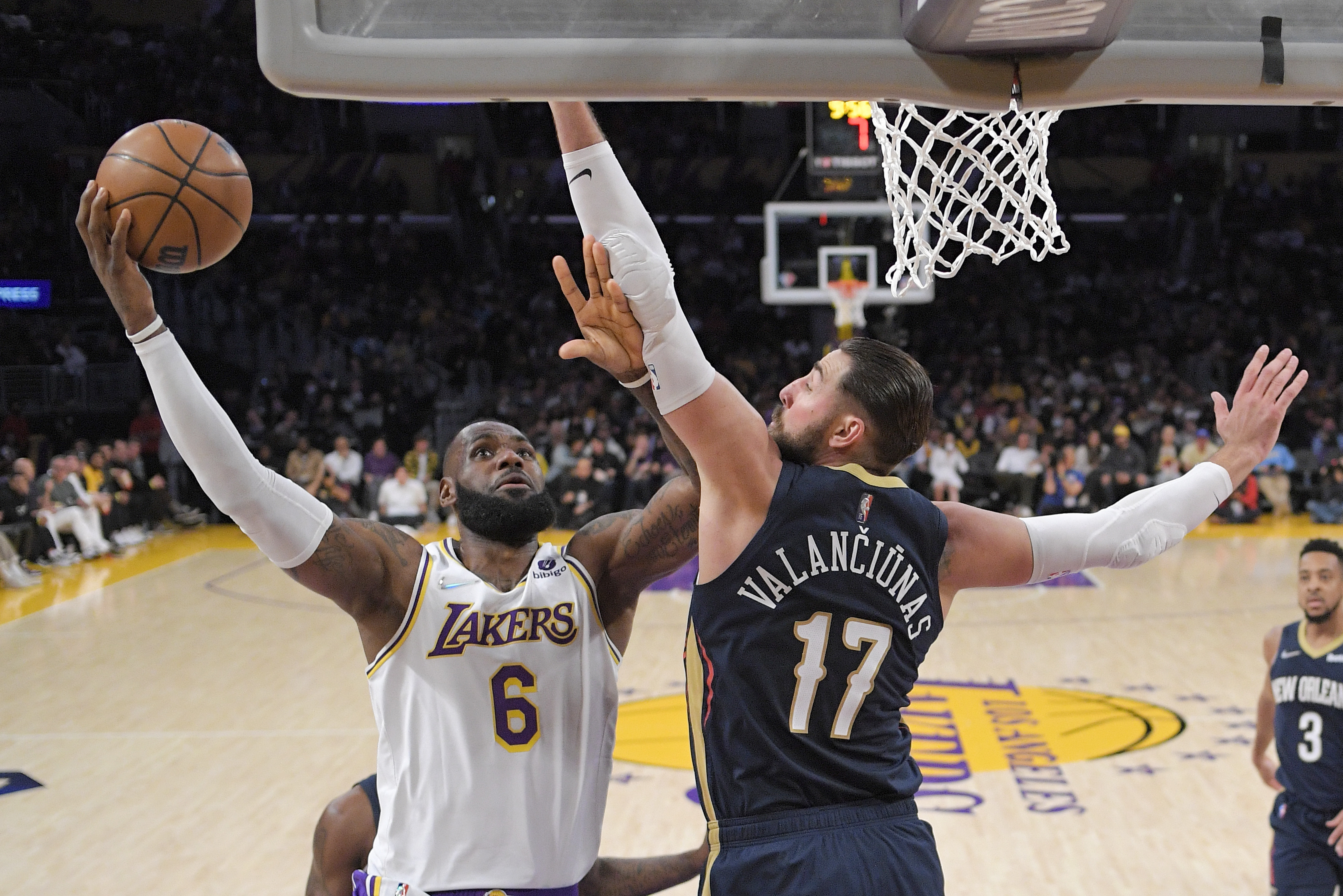 Los Angeles Lakers forward LeBron James, left, shoots as New Orleans Pelicans center Jonas Valanciunas defends during the first half of an NBA basketball game Sunday, Feb. 27, 2022, in Los Angeles. (AP Photo/Mark J. Terrill)