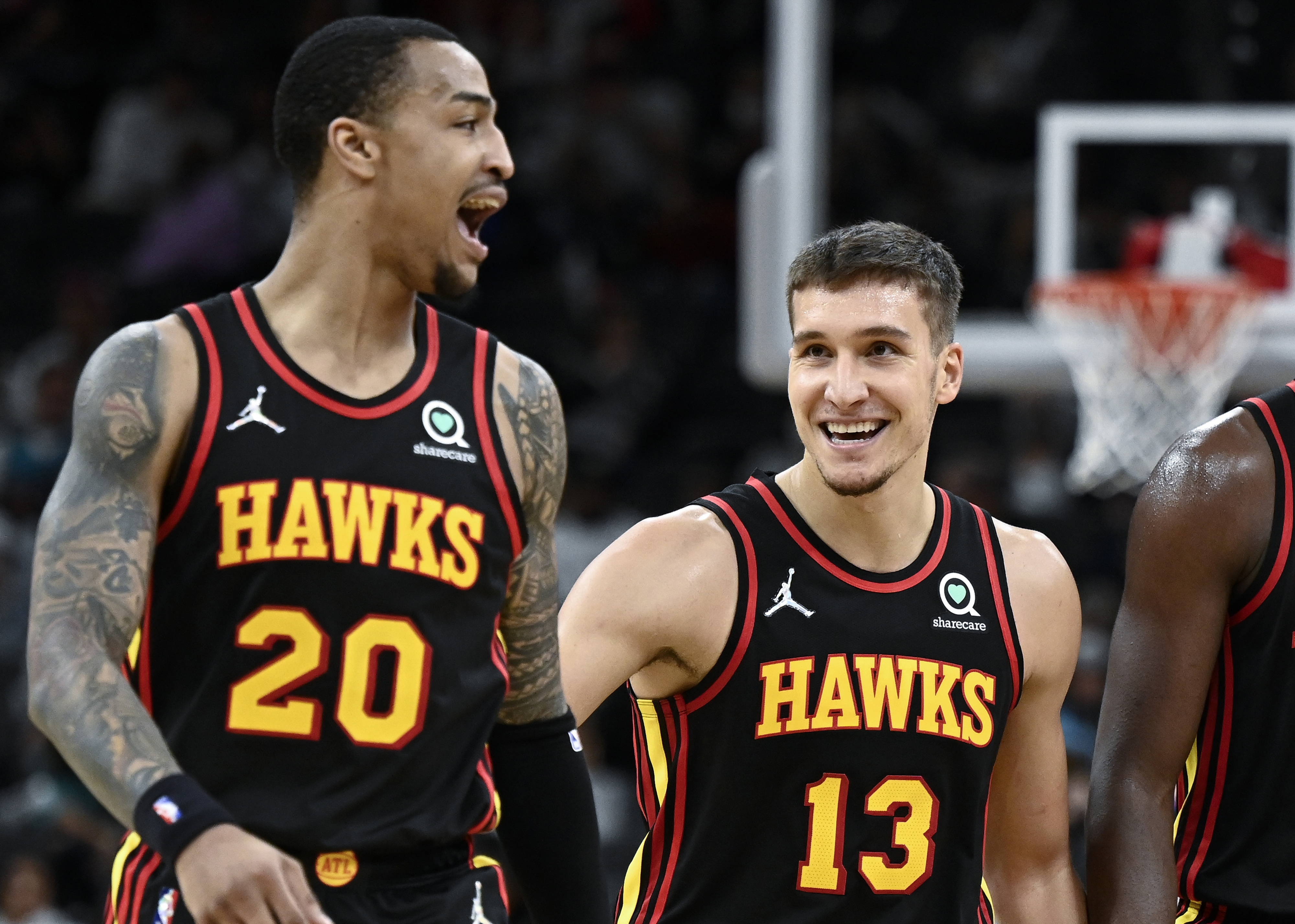 Atlanta Hawks' Bogdan Bogdanovic (13) and John Collins celebrate a basket late in the second half of an NBA basketball game against the San Antonio Spurs, Wednesday, Nov. 24, 2021, in San Antonio. Atlanta won 124-106. (AP Photo/Darren Abate)