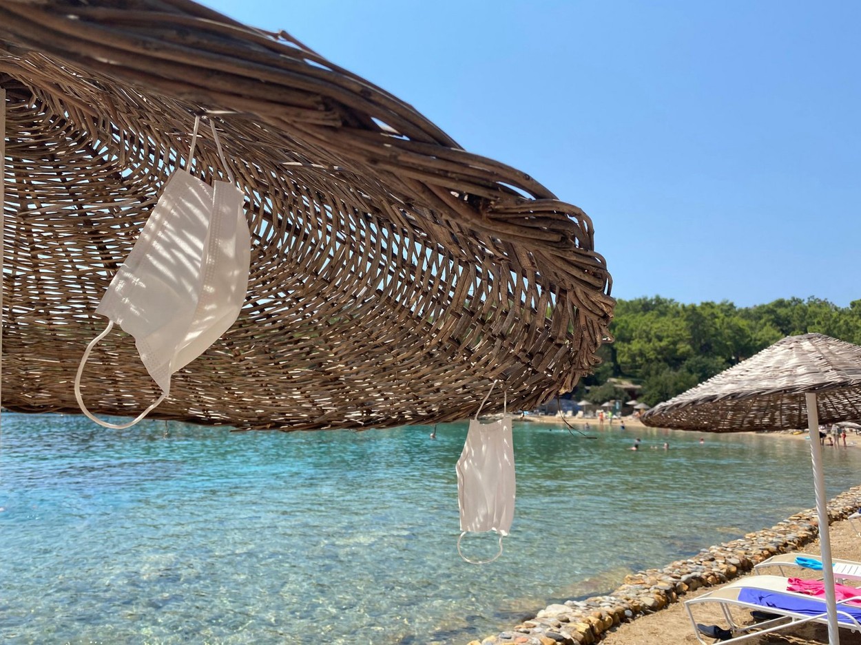 Masks hanging on a straw parasol on the beach