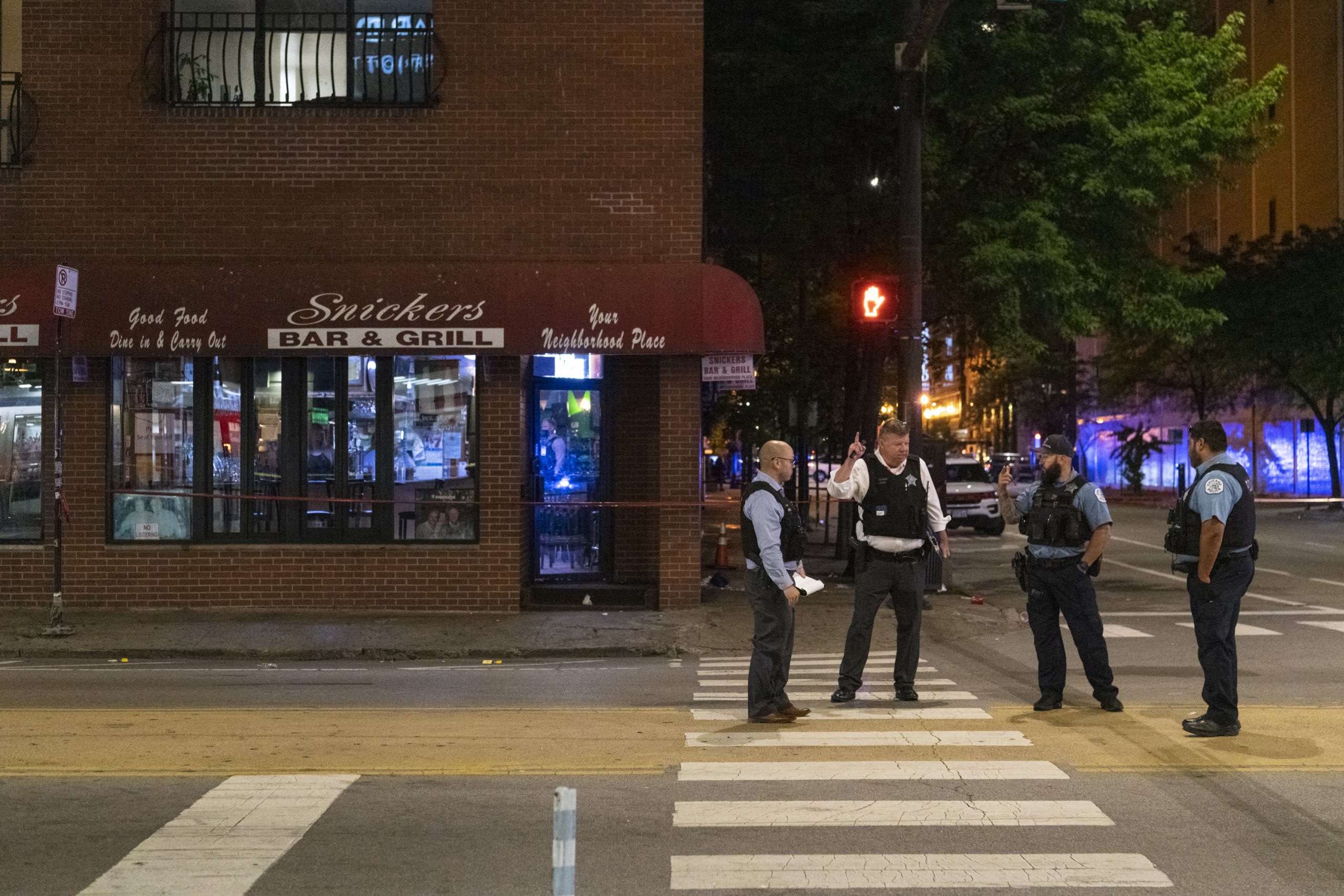 Chicago police work the scene of a shooting outside Snickers Bar &amp; Grill, in the River North neighborhood, Sunday, July 10, 2022. (Tyler Pasciak LaRiviere/Chicago Sun-Times via AP)