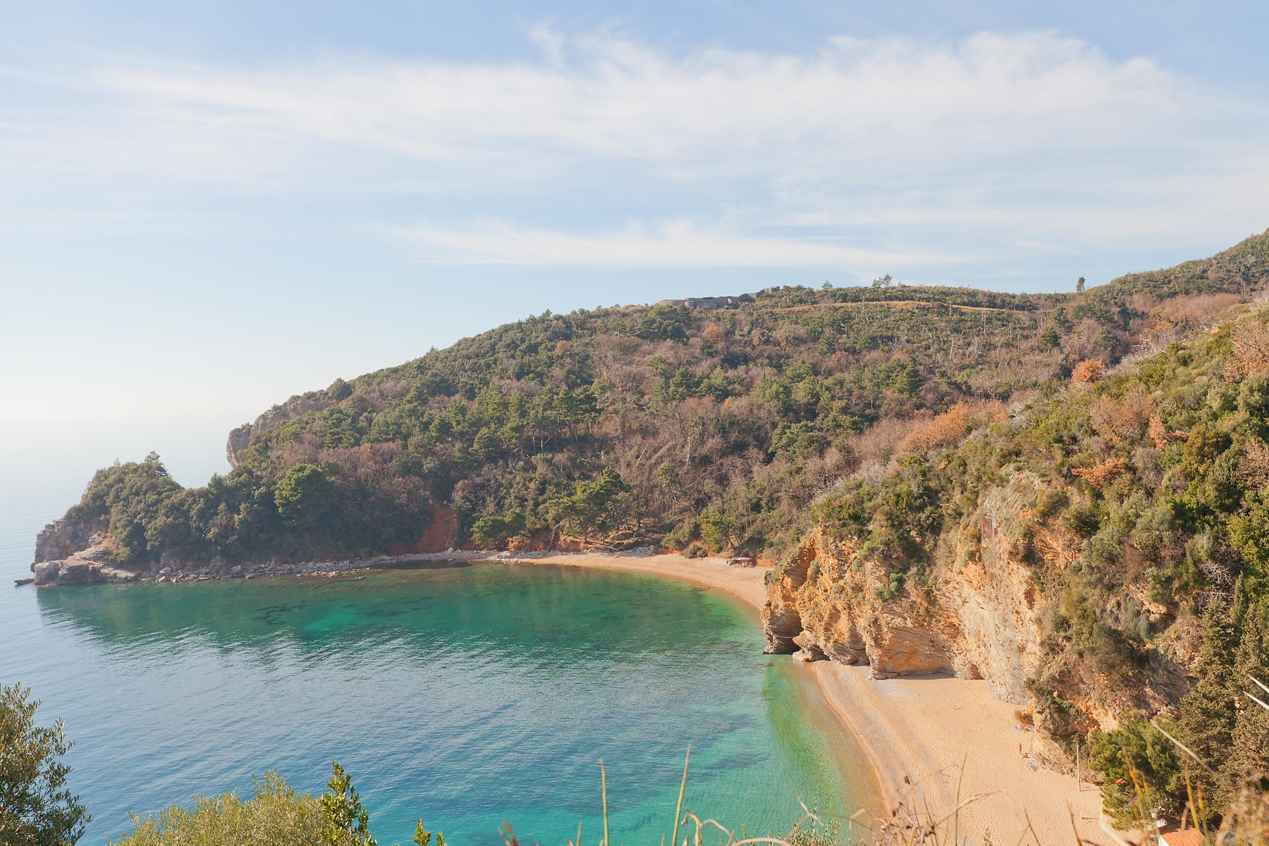 Mogren Cape and Mogren Beach near Budva town, Montenegro. Ruins of Mogren Fort (circa 1860) are on the top of the hill