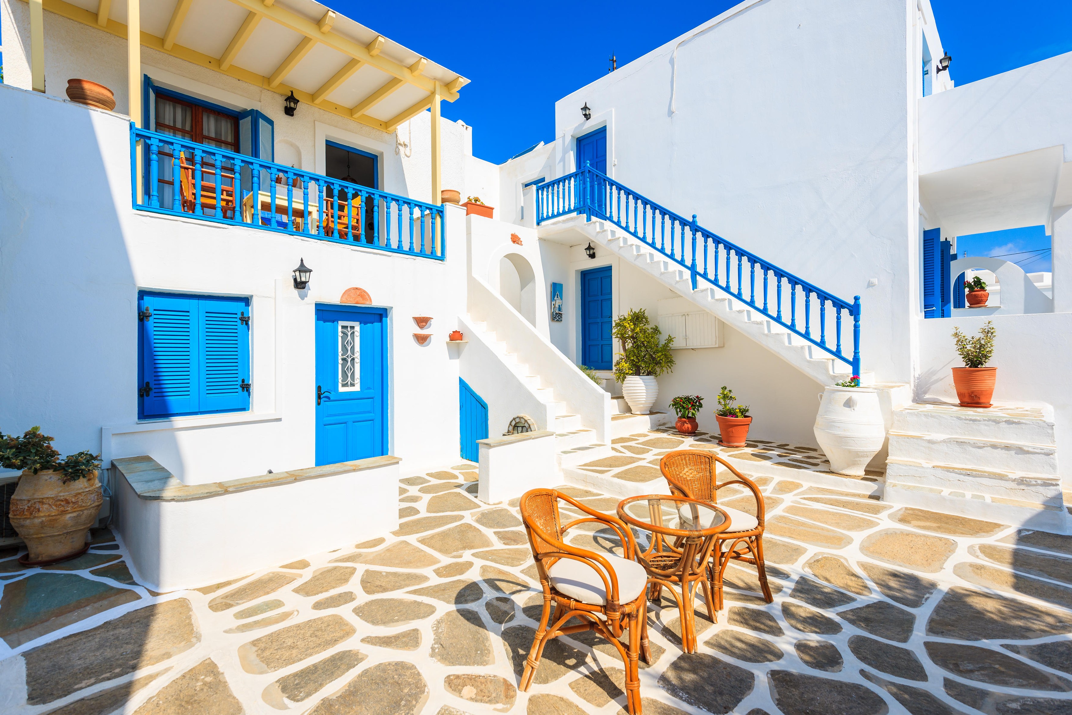 NAOUSSA TOWN, PAROS ISLAND - MAY 19, 2016: table with chairs on courtyard of typical Greek style apartment complex in Naoussa town on Paros island, Greece.