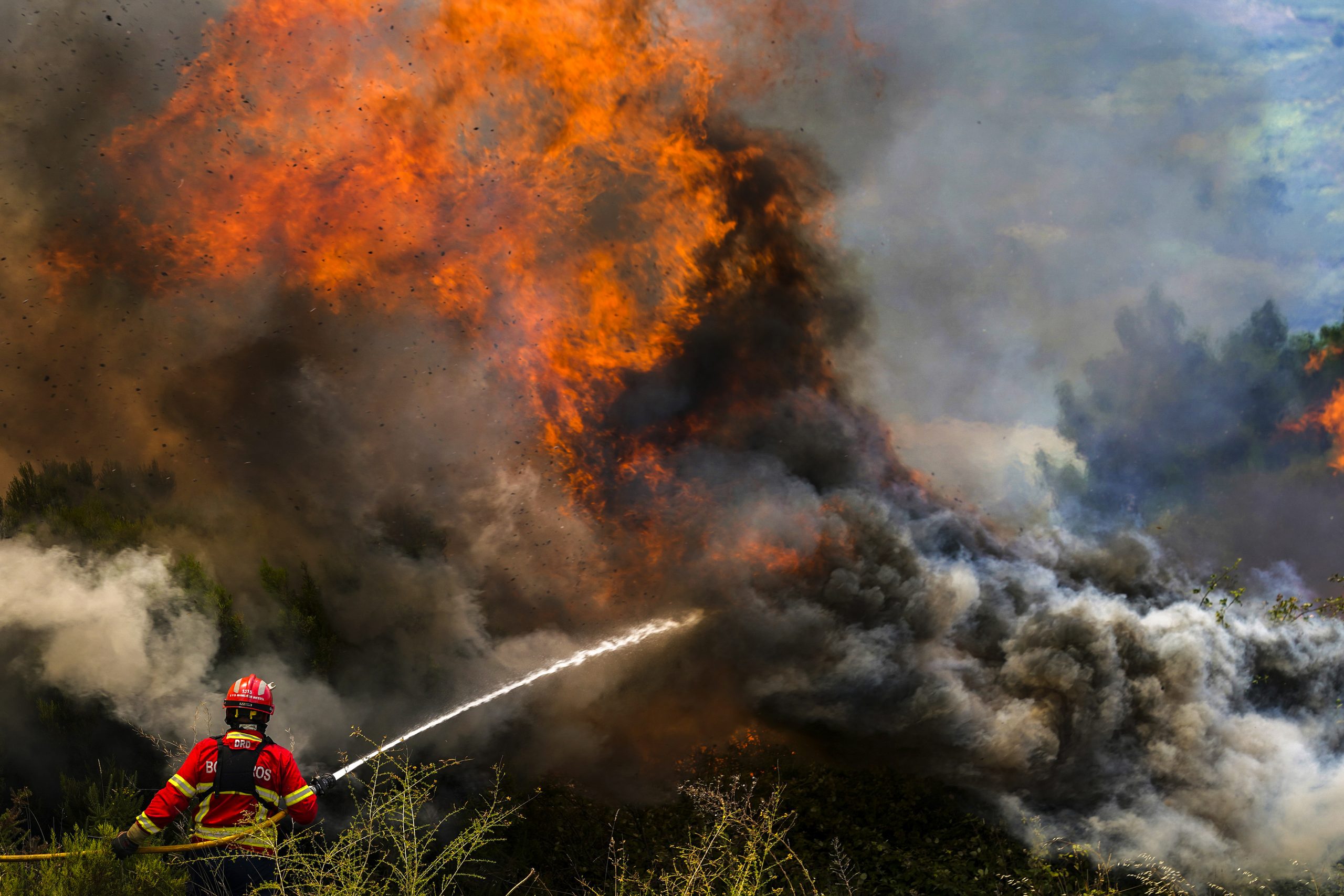 epaselect epa10072751 A firefighter fights the flames surrounding Ancede village during a wildfire in the municipality of Baiao, North of Portugal, 15 July 2022.  EPA-EFE/HUGO DELGADO