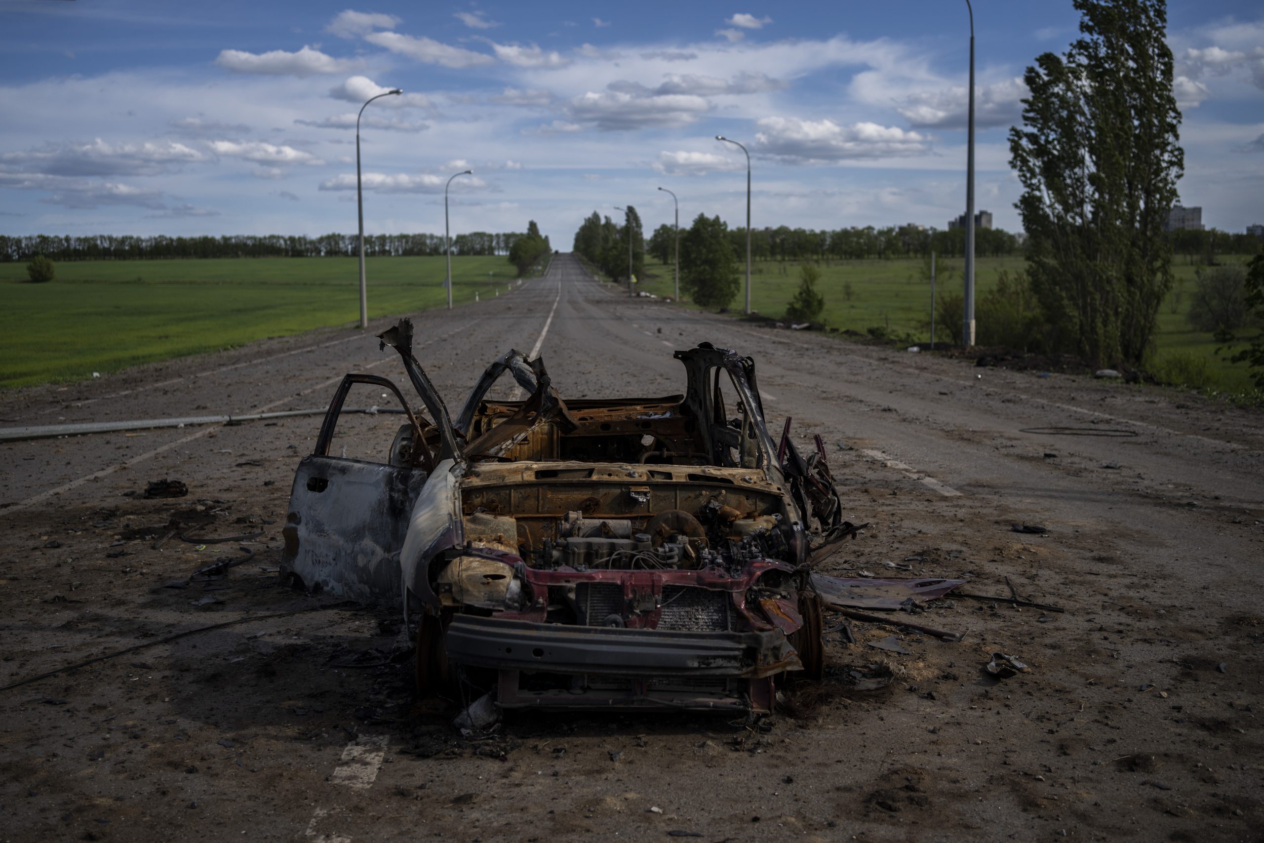 A destroyed vehicle lies in the middle of a road in north Kharkiv, east Ukraine, Friday, May 13, 2022. (AP Photo/Bernat Armangue)