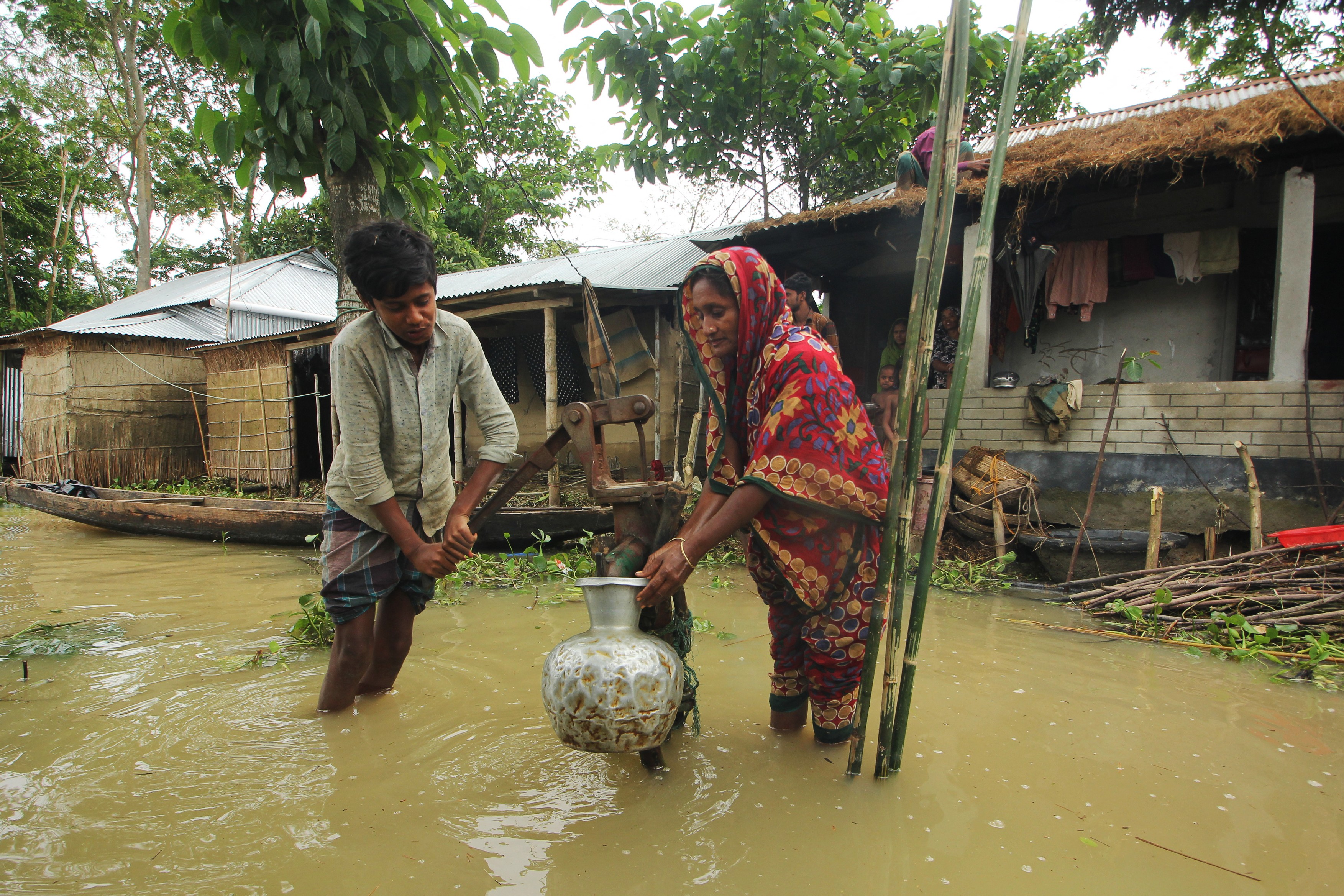 A family collects drinking from a tube well in a flooded area following heavy rain in Goyainghat on May 20, 2022.,Image: 693050070, License: Rights-managed, Restrictions: , Model Release: no, Credit line: Mamun Hossain / AFP / Profimedia
