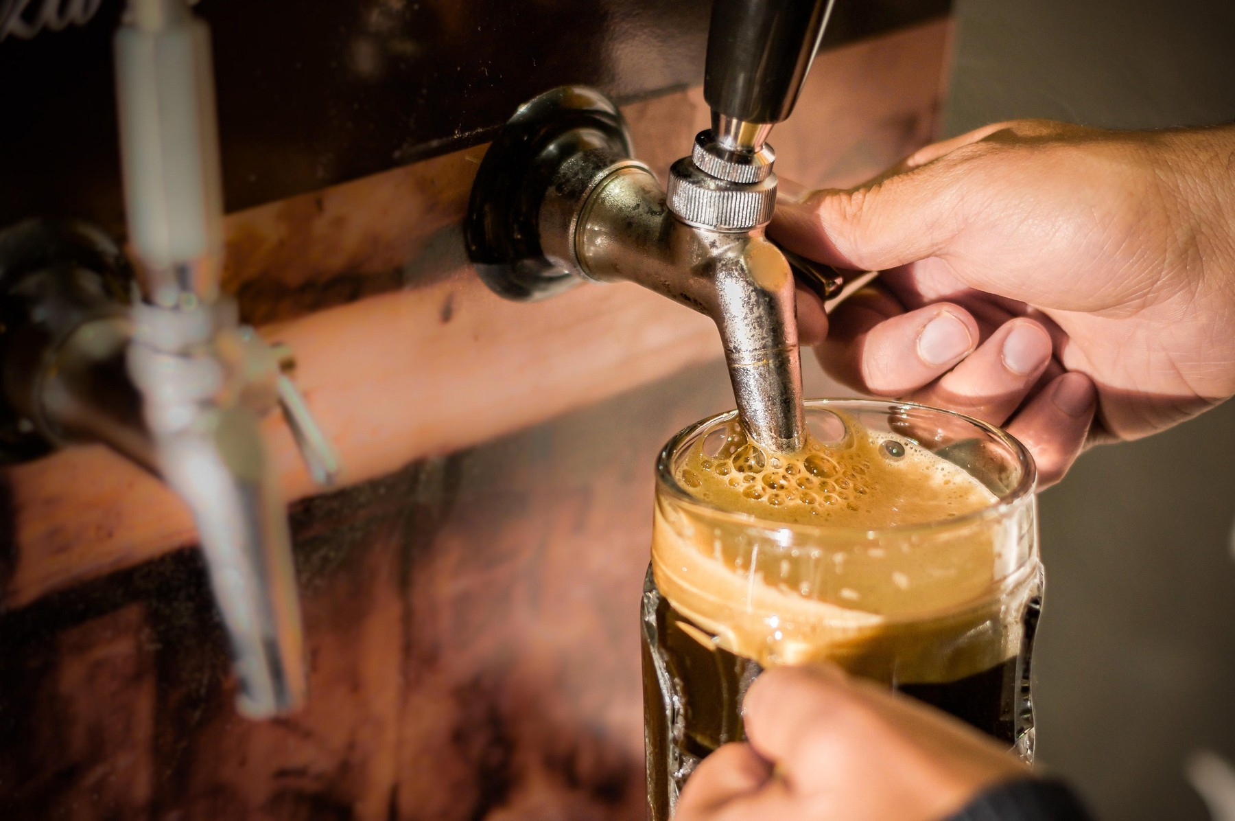 Bartender filling up with craft beer a pint glass