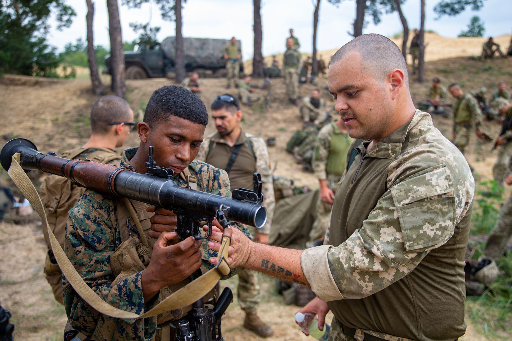 Ukrainian Marine Pvt. Aiden Aslin, a native of Nottingham, England and a rifleman with Air Assault Company, 1st Marine Battalion, 36th Naval Infantry Brigade, familiarizes U.S. Marine Corps Lance Cpl. Josef Mason, a native of New York City and a rifleman