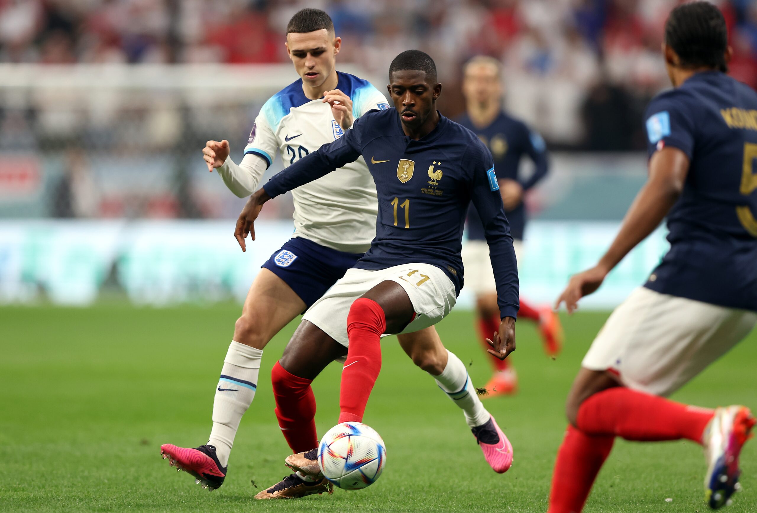 epa10359892 Phil Foden (L) of England in action against Ousmane Dembele of France during the FIFA World Cup 2022 quarter final soccer match between England and France at Al Bayt Stadium in Al Khor, Qatar, 10 December 2022.  EPA-EFE/Tolga Bozoglu