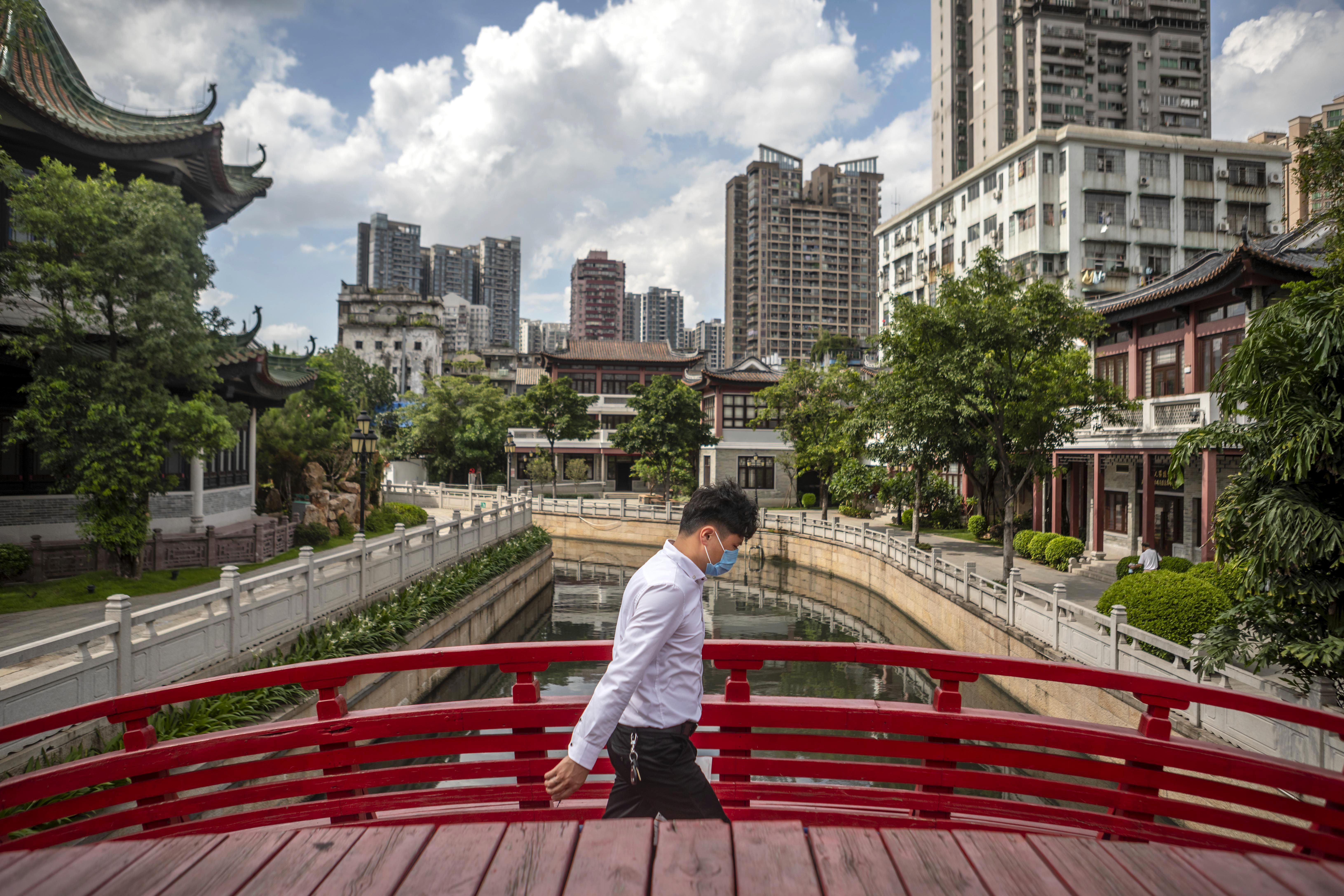 epa08501633 A man wearing a protection mask crosses a bridge in Guangzhou, China, 22 June 2020. China races to contain a second wave of coronavirus cases mostly in Beijing.  EPA-EFE/ALEX PLAVEVSKI