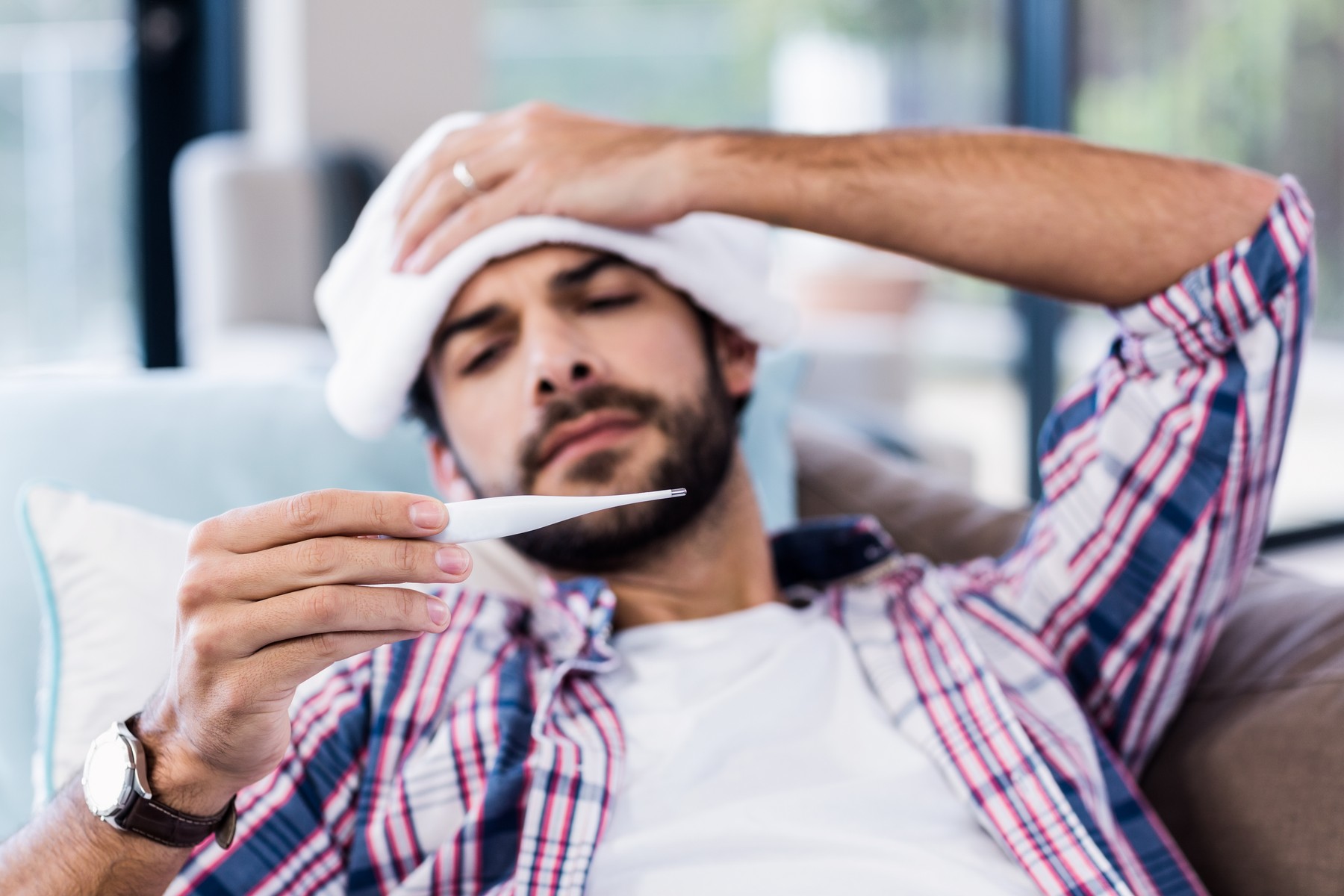 Sick man checking temperature