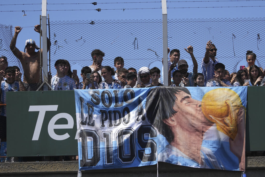 Fans watch from an overpass the homecoming parade of the Argentine soccer team that won the World Cup tournament in Buenos Aires, Argentina, Tuesday, Dec. 20, 2022. (AP Photo/Victor Caivano)