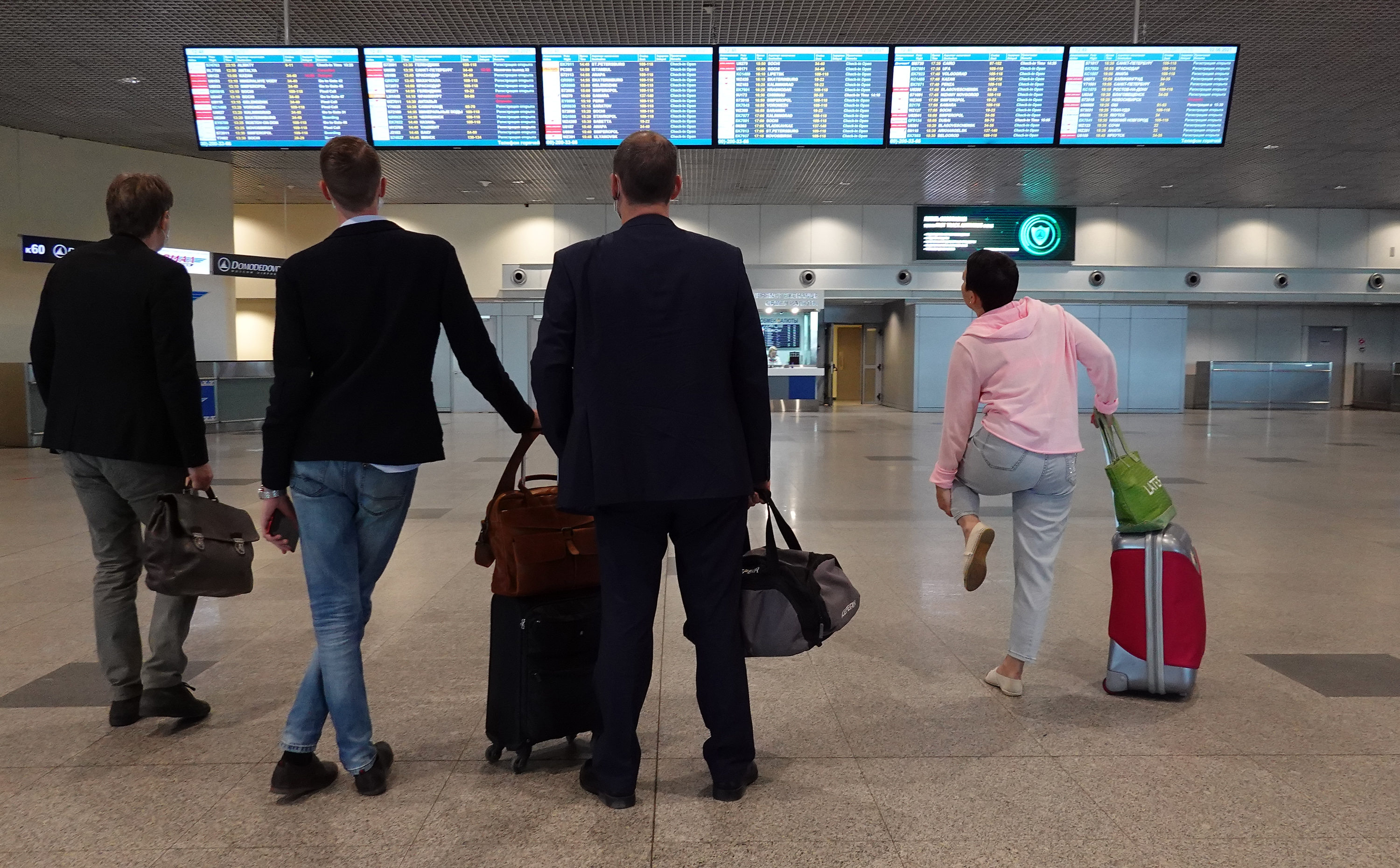 epa09242852 People look at the information board at airport Domodedovo in Moscow, Russia, 02 June 2021. German airline Lufthansa cancelled two flights from Frankfurt to Moscow and back bypass Belarus.  EPA-EFE/MAXIM SHIPENKOV