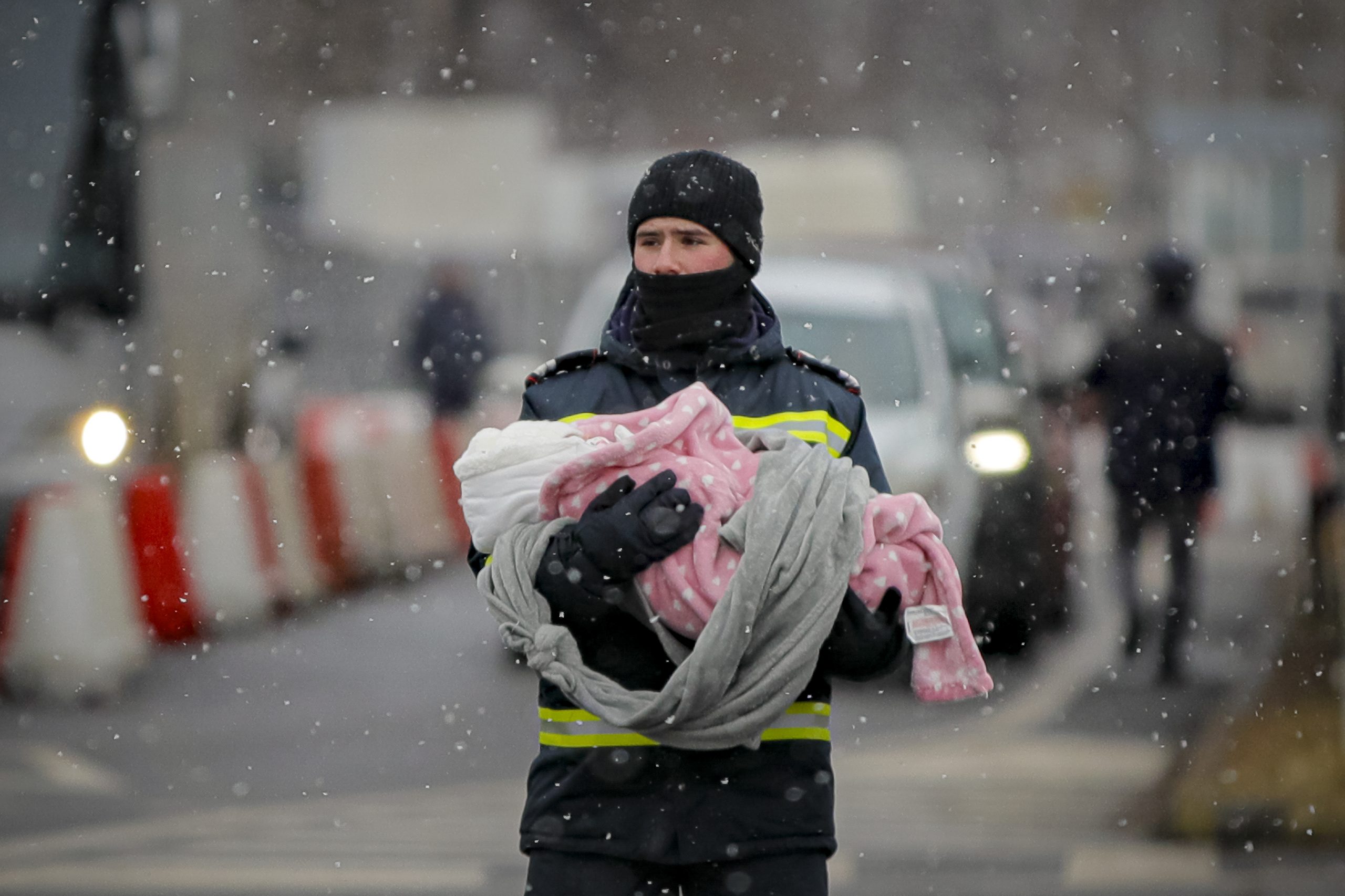 A firefighter holds the baby of a refugee fleeing the conflict from neighboring Ukraine at the Romanian-Ukrainian border, in Siret, Romania, Monday, March 7, 2022. (AP Photo/Andreea Alexandru)