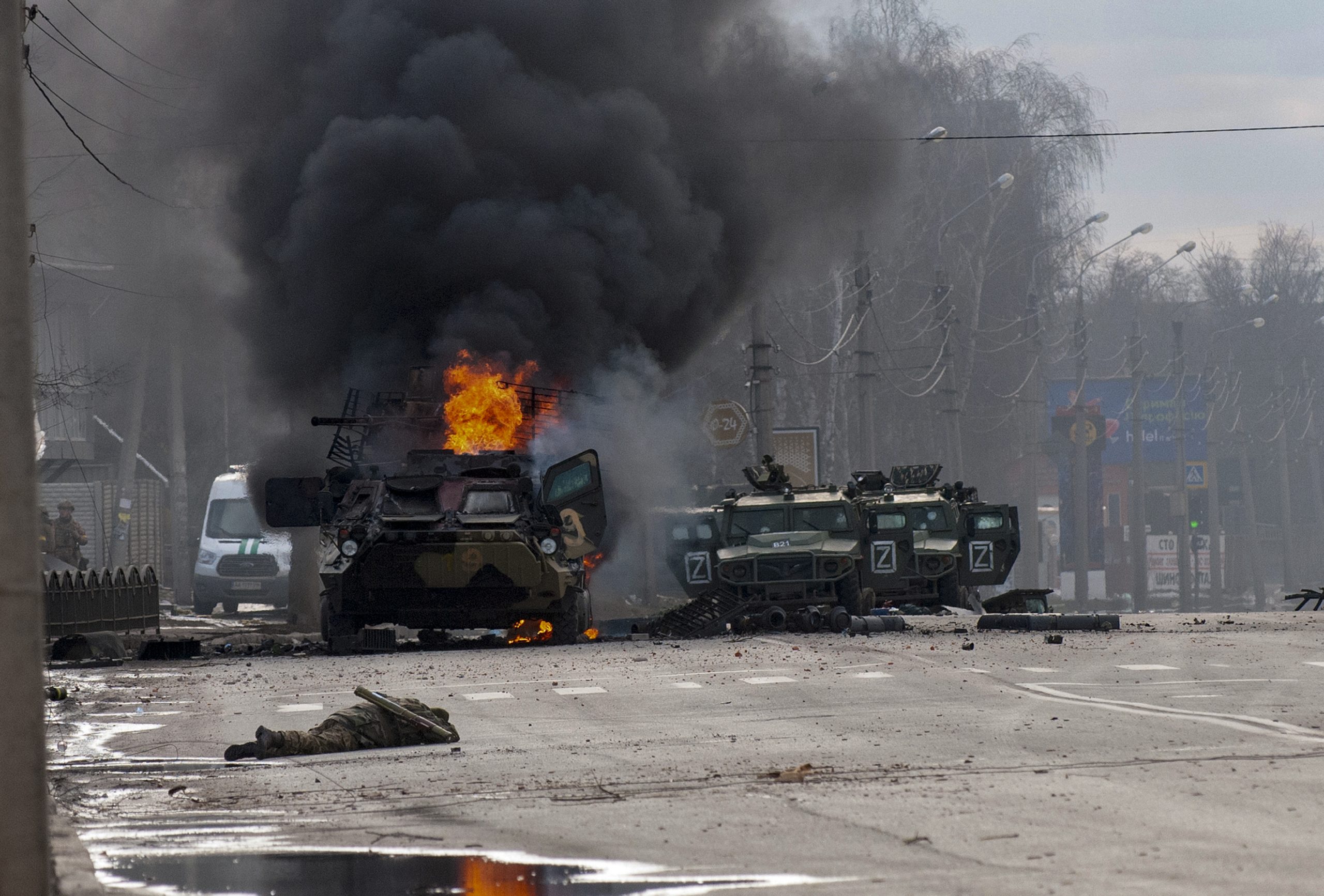 FILE - A Russian armored personnel carrier burns amid damaged and abandoned light utility vehicles after fighting in Kharkiv, Ukraine, Feb. 27, 2022. (AP Photo/Marienko Andrew, File)
