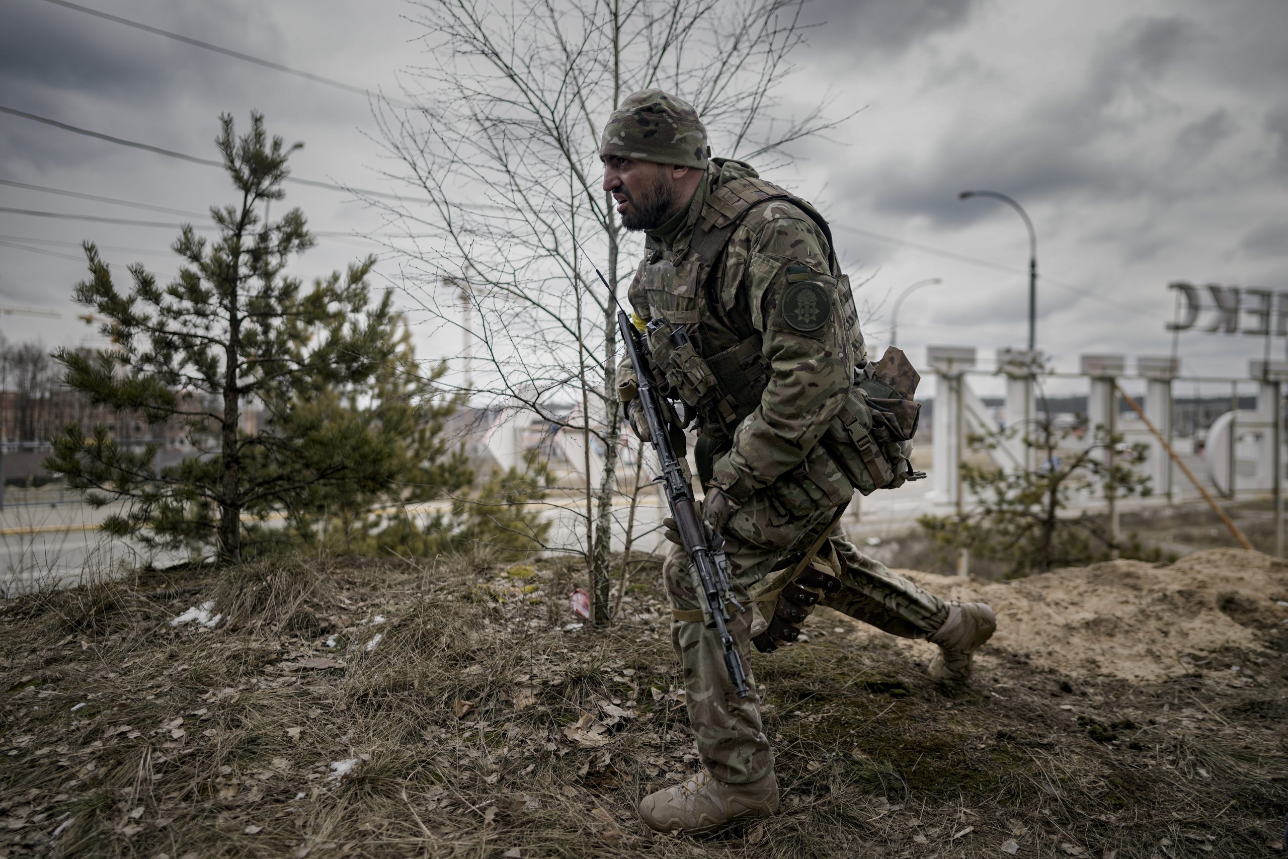 A Ukrainian serviceman takes a shooting position as he looks at approaching vehicles in Irpin, on the outskirts of Kyiv, Ukraine, Wednesday, March 9, 2022. (AP Photo/Vadim Ghirda)