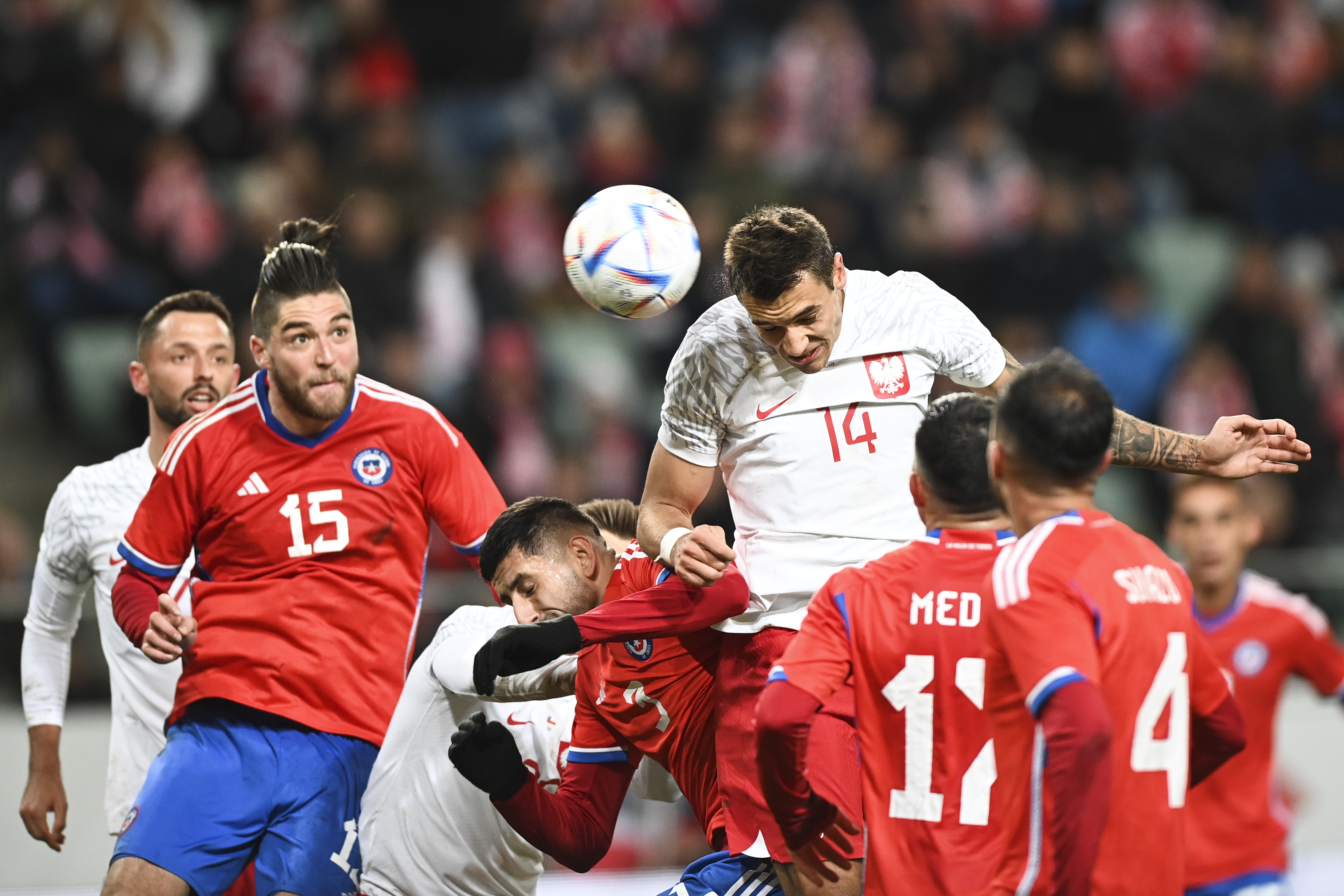 Poland's Jakub Kiwior, right, heads for the ball during an international friendly soccer match between Poland and Chile at the Polish Army Stadium in Warsaw, Poland Wednesday, Nov. 16, 2022. (AP Photo/Rafal Oleksiewicz)
