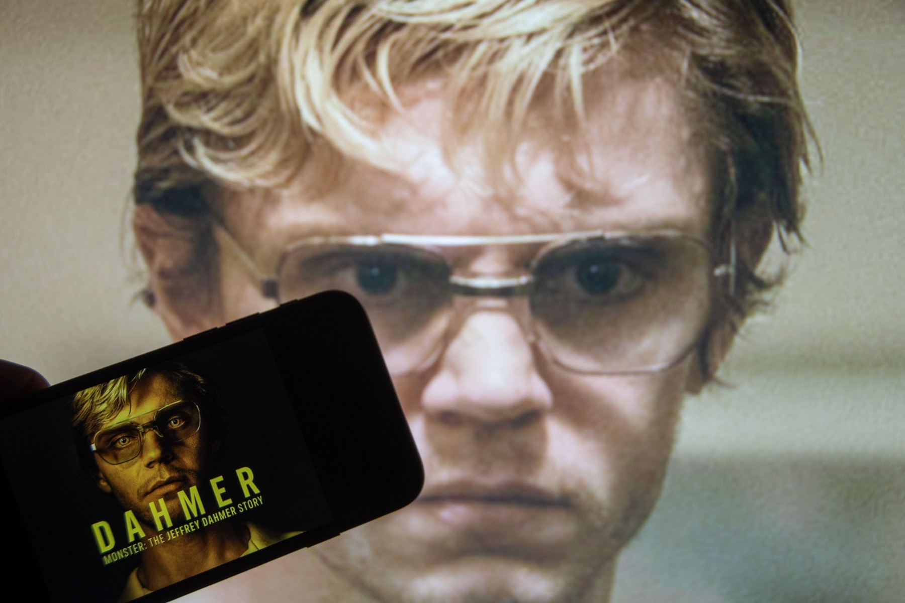 Rheinbach, Germany  9 October 2022,  The logo of the successful Netflix series "Dahmer" on the display of a smartphone in front of a scene on TV
