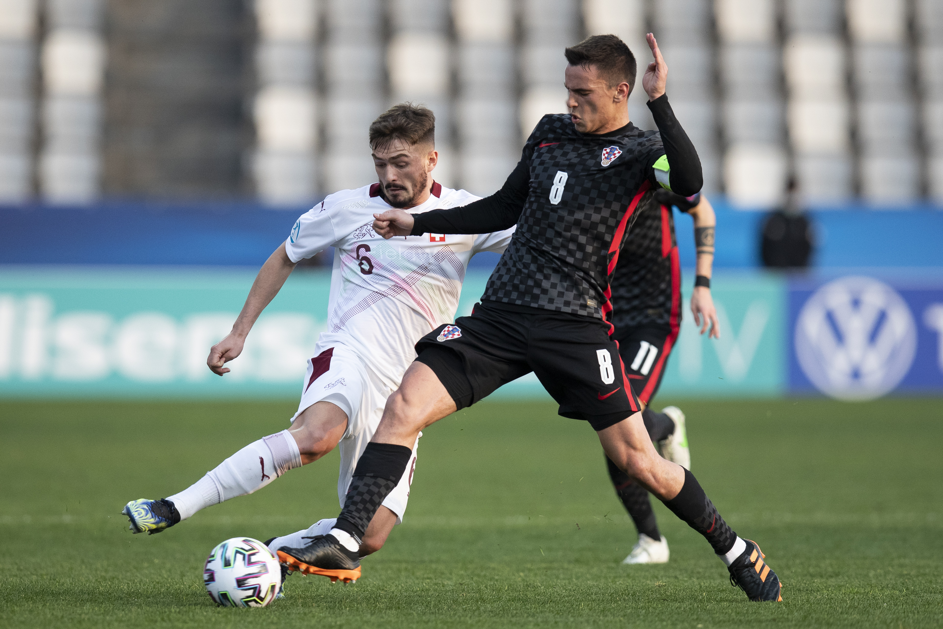 epa09103451 Switzerland's Toni Domgjoni (L) and Croatia's Nikola Moro in action during the UEFA European Under 21 Championship match between Croatia and Switzerland in Koper, Slovenia, 28 March 2021.  EPA-EFE/PETER KLAUNZER