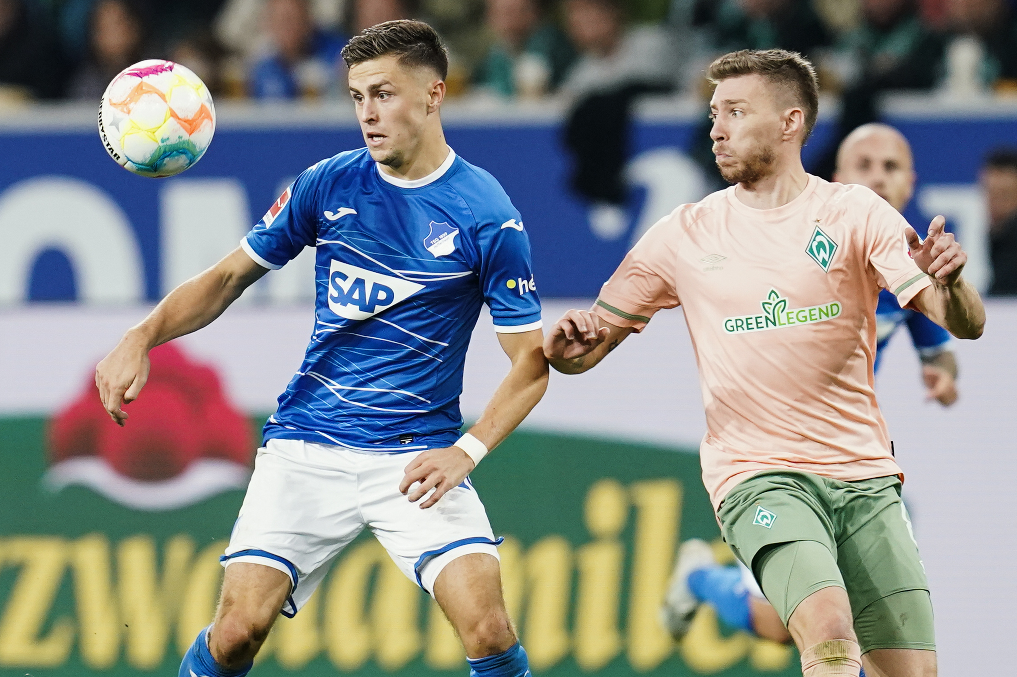 Hoffenheim's Christoph Baumgartner, left, and Bremen's Mitchel Weiser fight for the ball during the German Bundesliga soccer match between TSG 1899 Hoffenheim and Werder Bremen in Sinsheim, Germany, Friday, Oct. 7, 2022. (Uwe Anspach/dpa via AP)