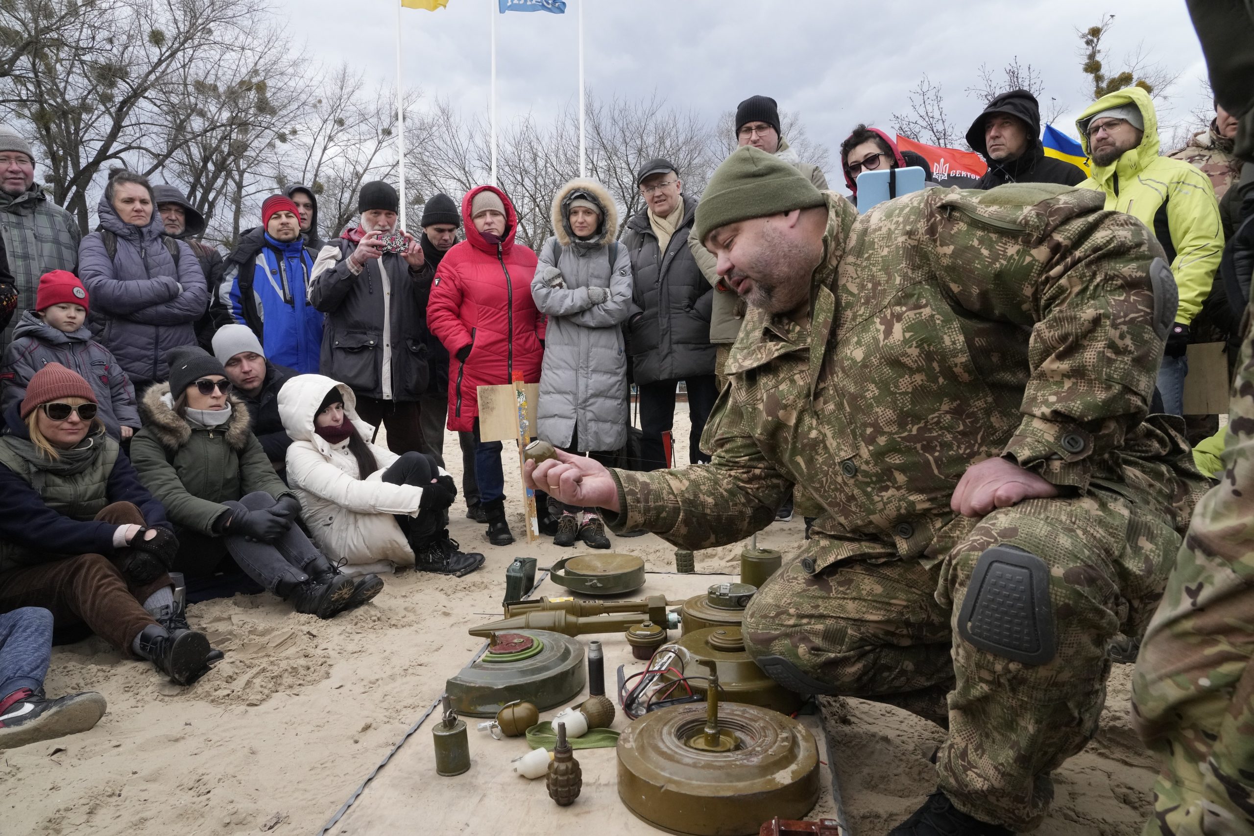 An instructor, right, shows a grenade during a training of members of a Ukrainian far-right group train, in Kyiv, Ukraine, Sunday, Feb. 20, 2022. (AP Photo/Efrem Lukatsky)