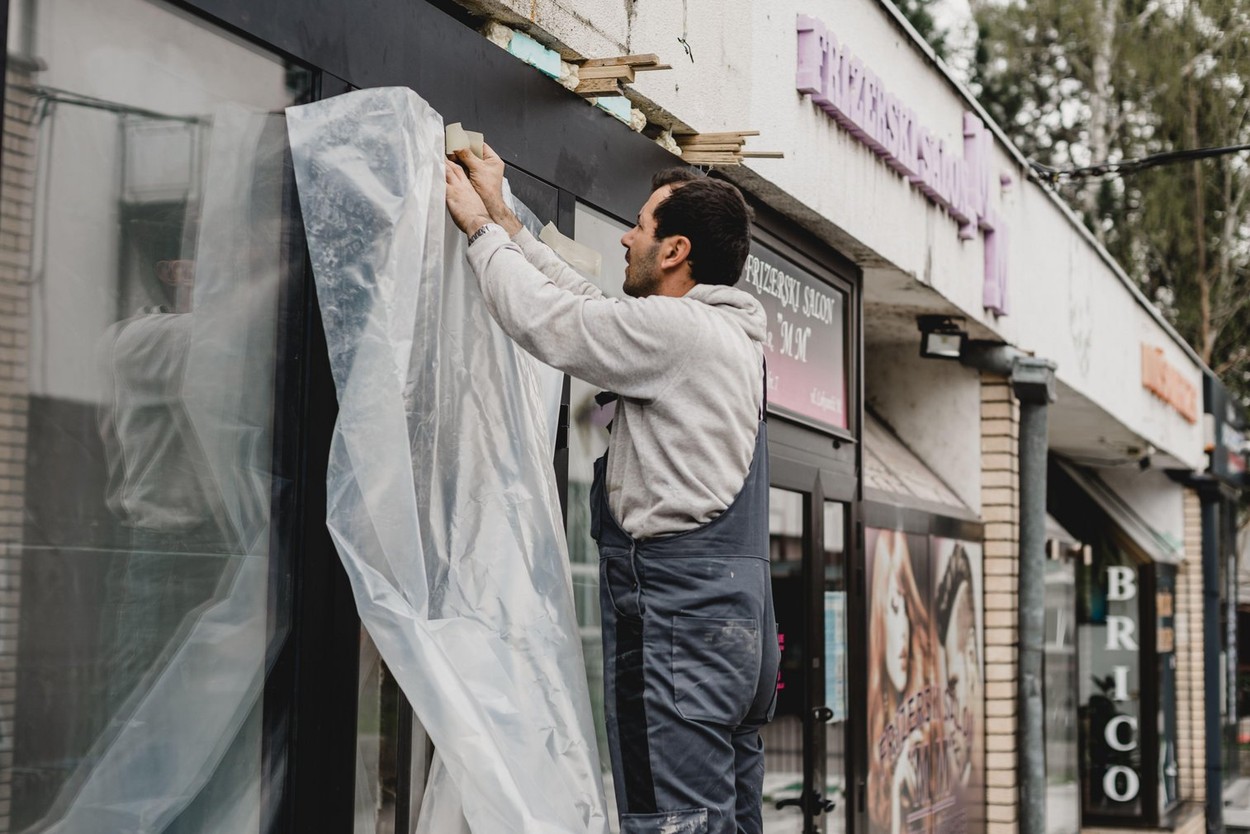 Sarajevo, Bosnia and Herzegovina - 26.04.2021: reopening the store, worker renewing the store front after covid 19 lockdown