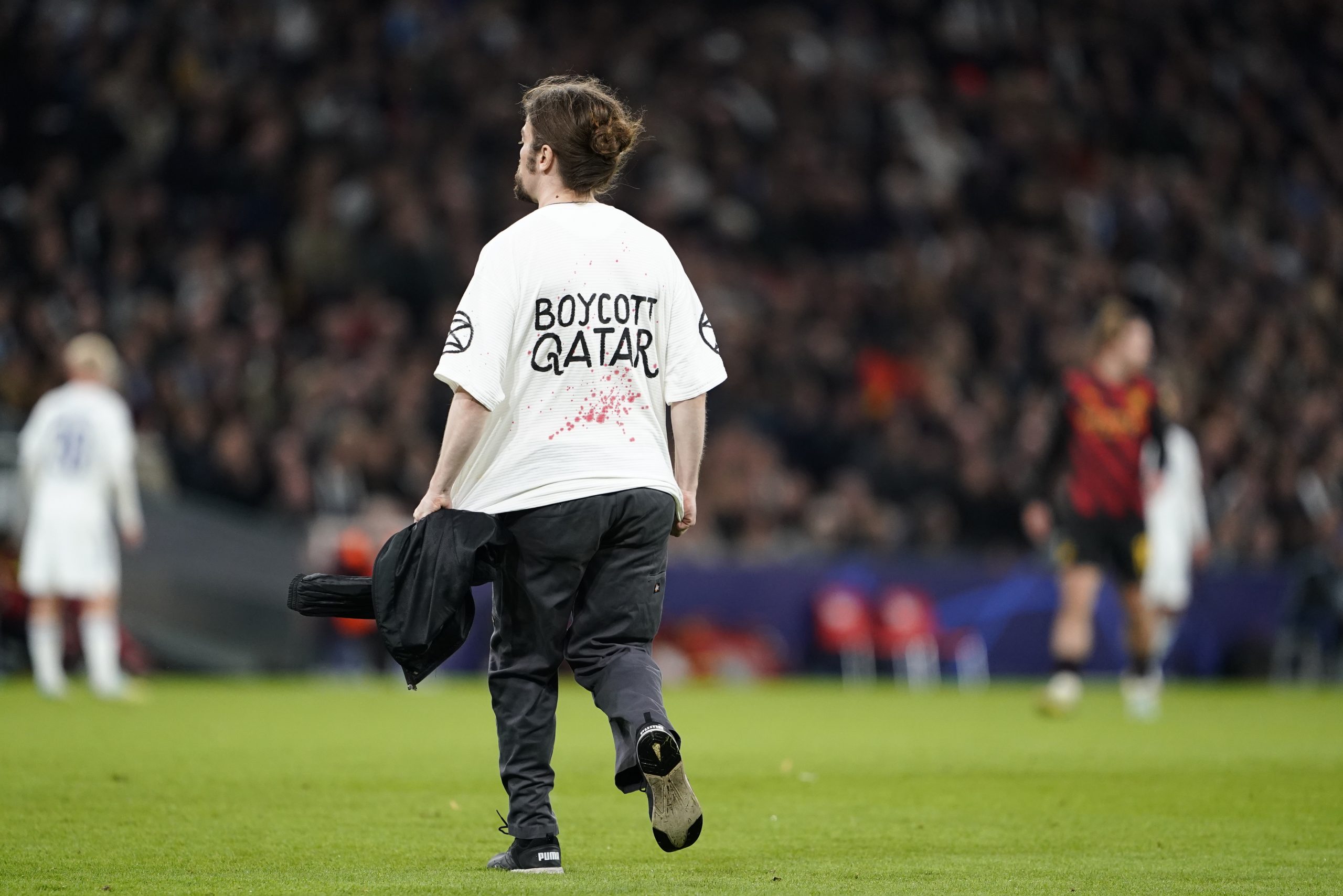 epa10236550 A protester on the pitch wearing a 'Boycott Qatar' shirt during the group G Champions League soccer match between FC Copenhagen and Manchester City FC in Copenhagen, Denmark, 11 October 2022.  EPA-EFE/Liselotte Sabroe  DENMARK OUT