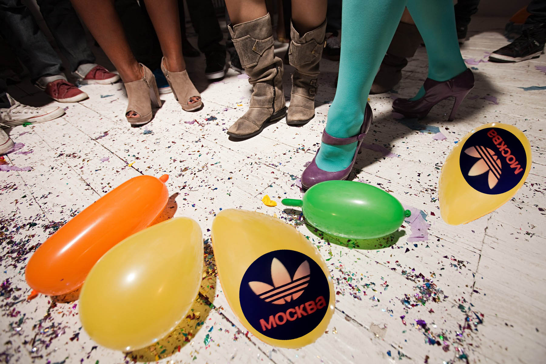 People dancing at party with balloons on floorboards