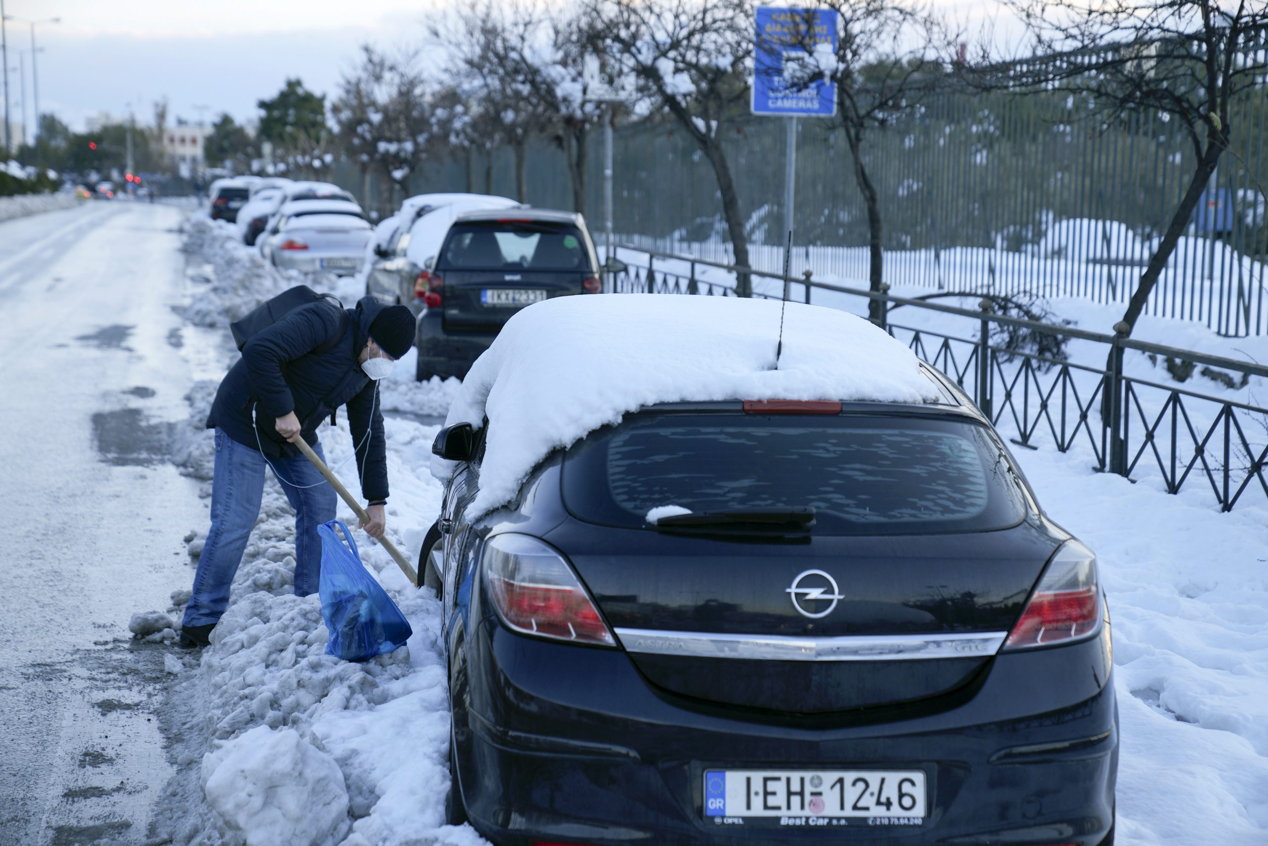 A man shovels to free from snow his car, in northern Athens following Tuesday's heavy snowfall, on Wednesday, Jan. 26, 2022. (AP Photo/Thanassis Stavrakis)