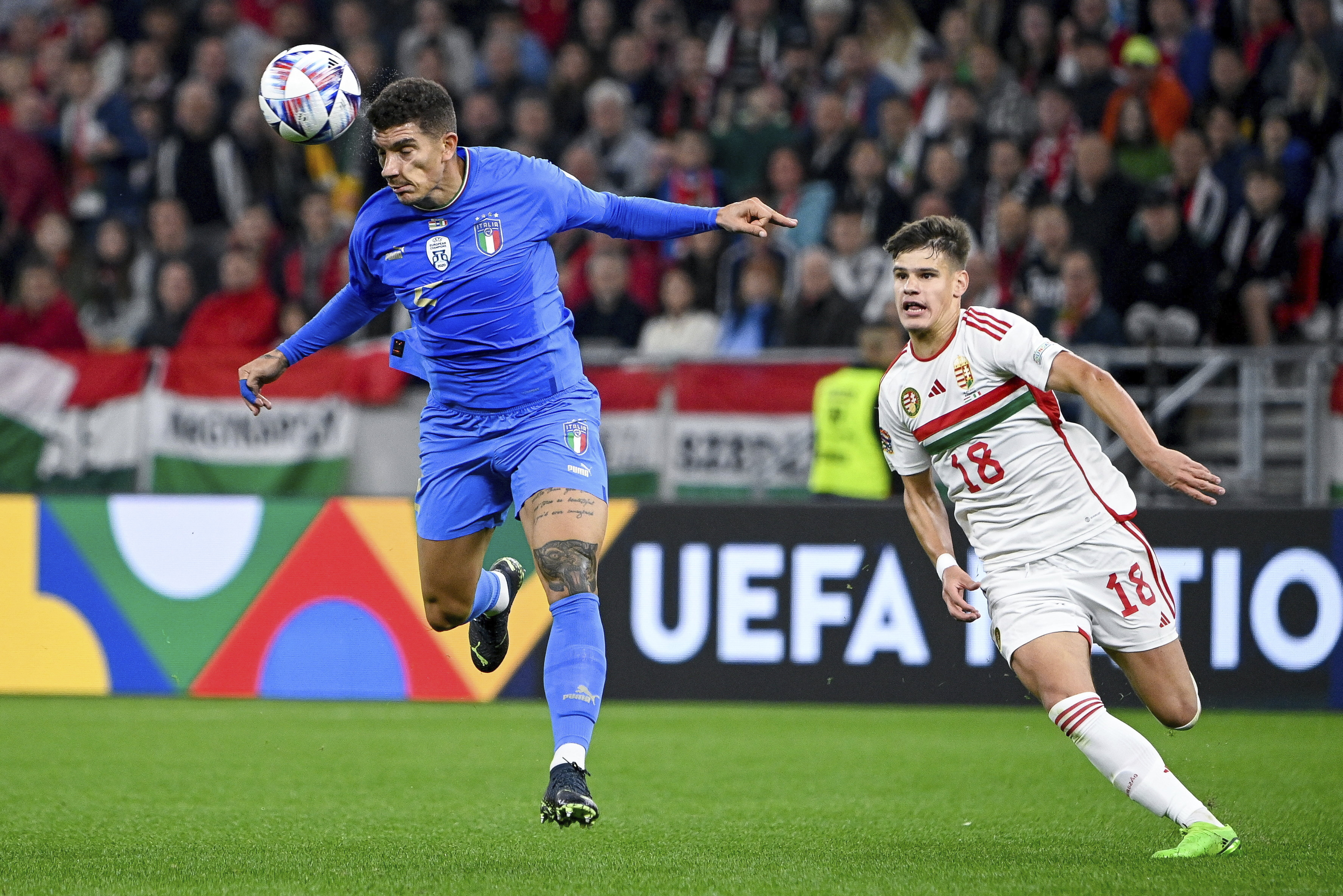 Italy's Giovanni Di Lorenzo, left, vies for the ball with Hungary's Milos Kerkez, during the UEFA Nations League soccer match between Hungary and Italy, at the Puskas Arena in Budapest, Hungary, Monday, Sept. 26, 2022. (Zsolt Szigetvary/MTI via AP)
