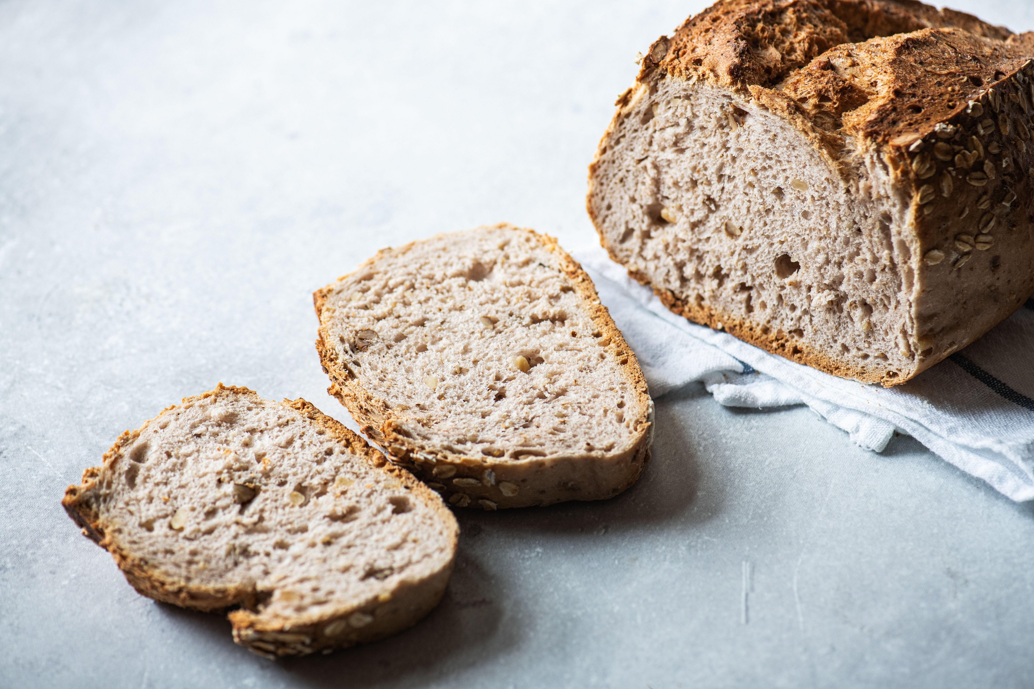 Close up of sliced bread on a gray background.