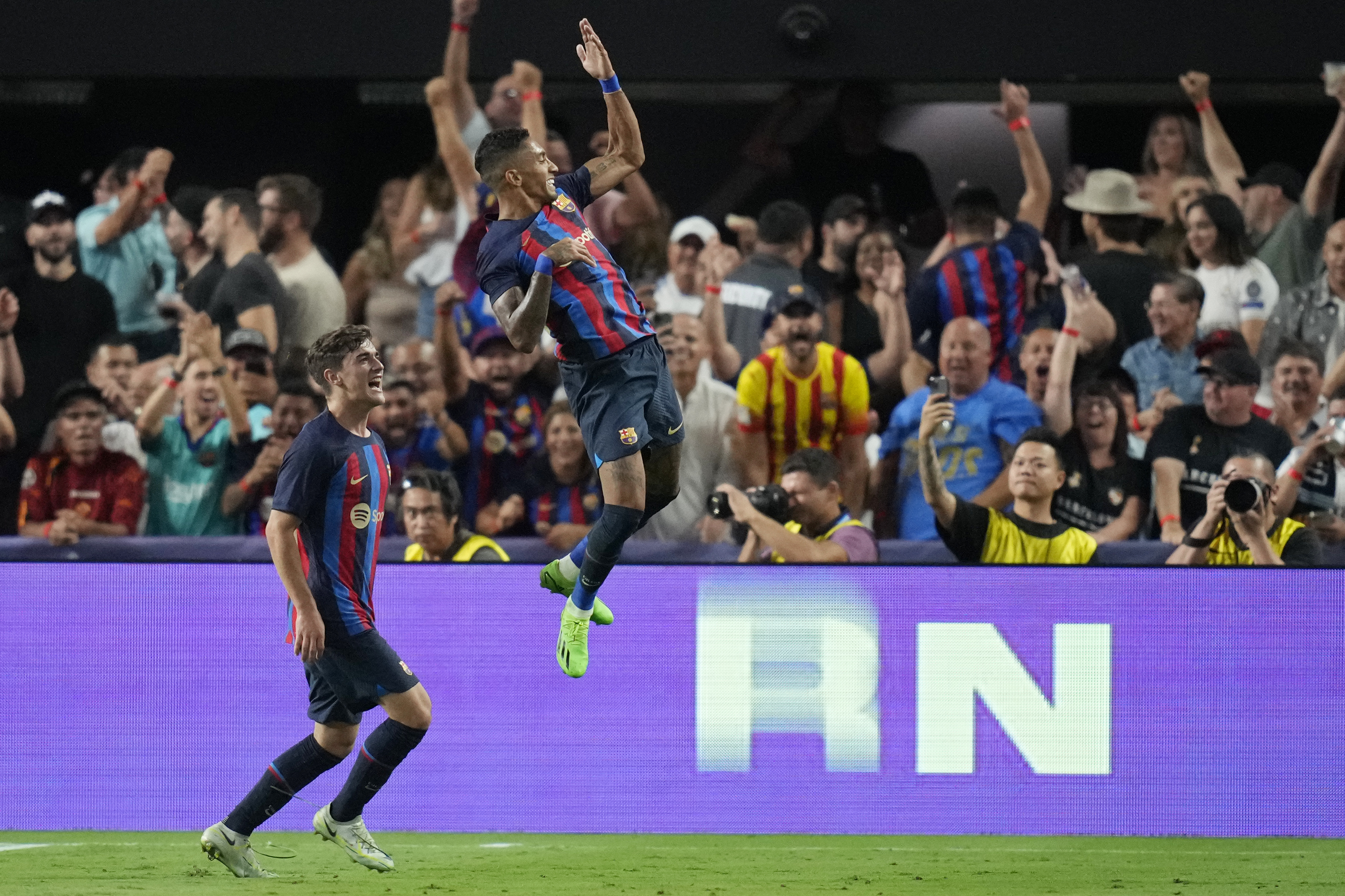 Barcelona's Raphael Dias, right, celebrates after scoring against Real Madrid during the first half of a friendly soccer match Saturday, July 23, 2022, in Las Vegas. (AP Photo/John Locher)