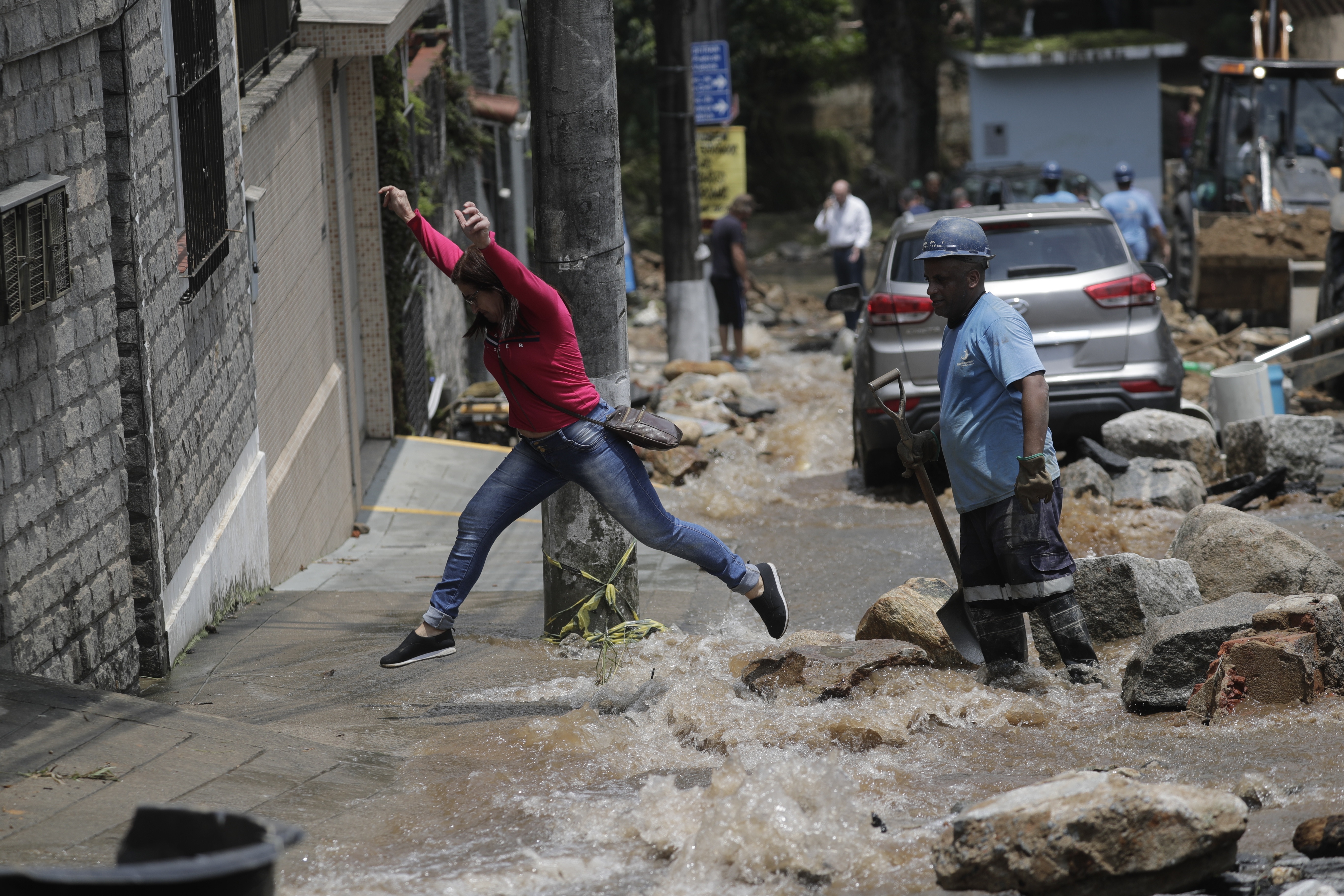 epa09763043 People criss a rocky street amid damage caused by the heavy rains that affect the city of Petropolis, RJ, Brazil, 16 February 2022. At least 38 people have died in Petropolis in floods following heavy rains.  EPA-EFE/Antonio Lacerda