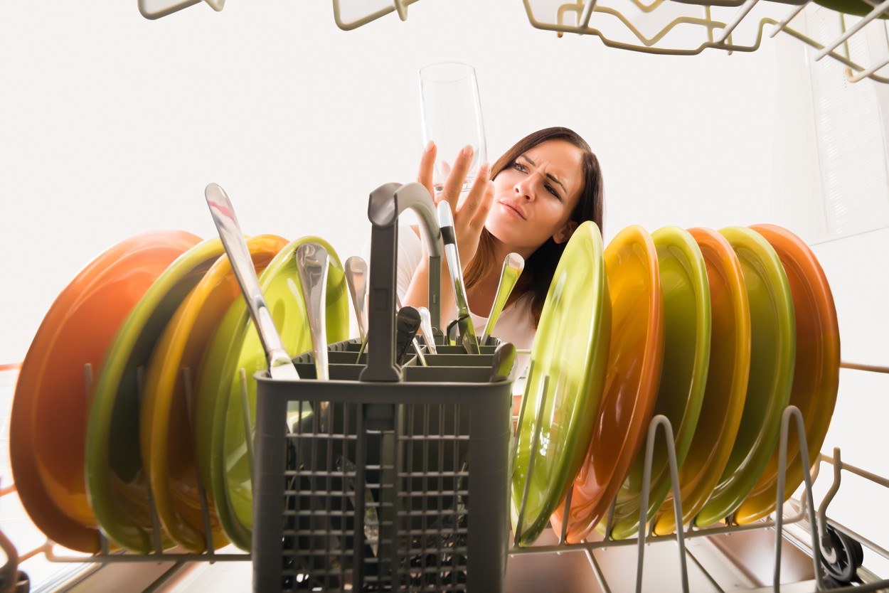 Woman Looking At Glass In Dishwasher