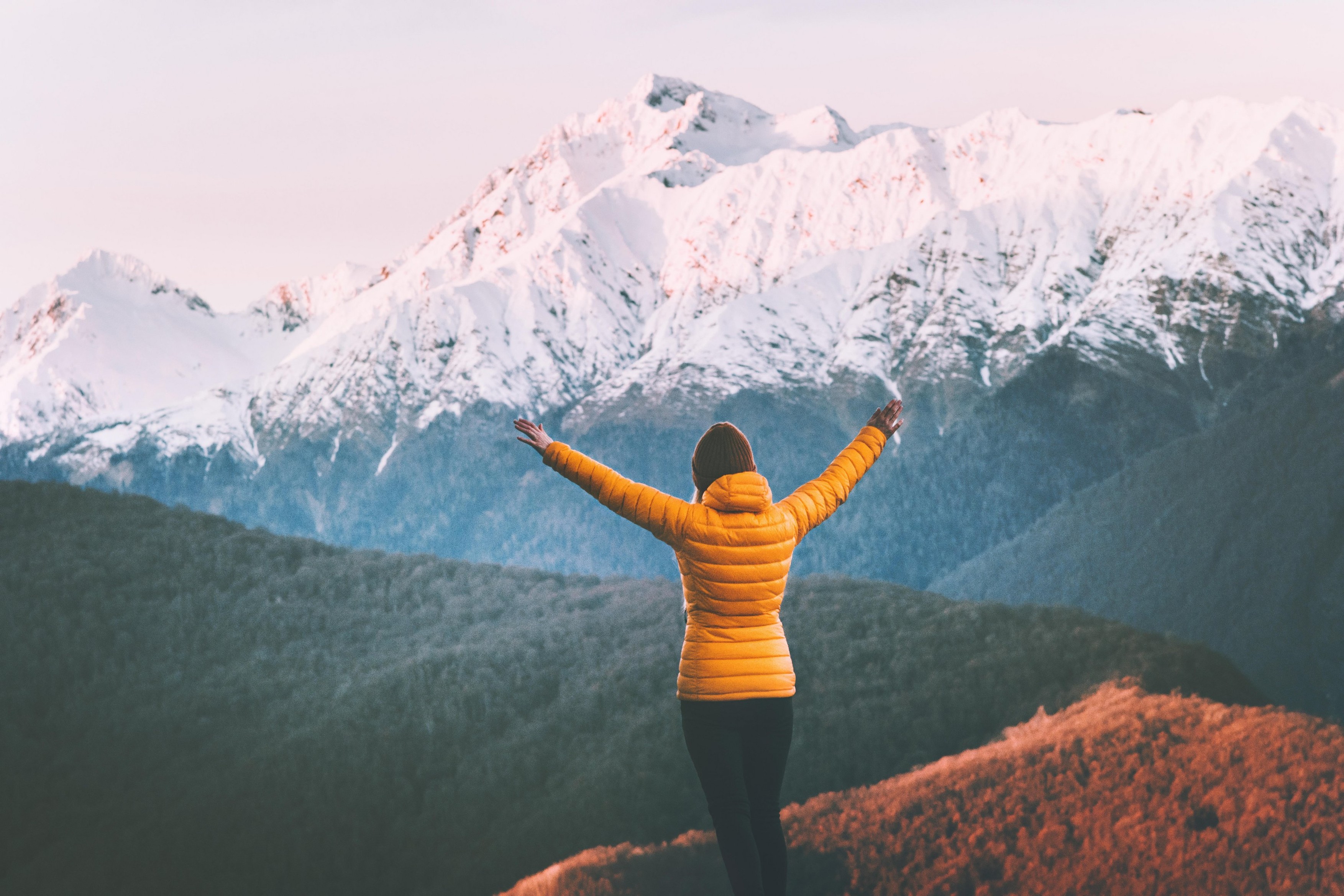 Woman enjoying snowy mountains view adventure lifestyle solo traveling winter vacations outdoor girl raised hands hiking alone harmony with nature