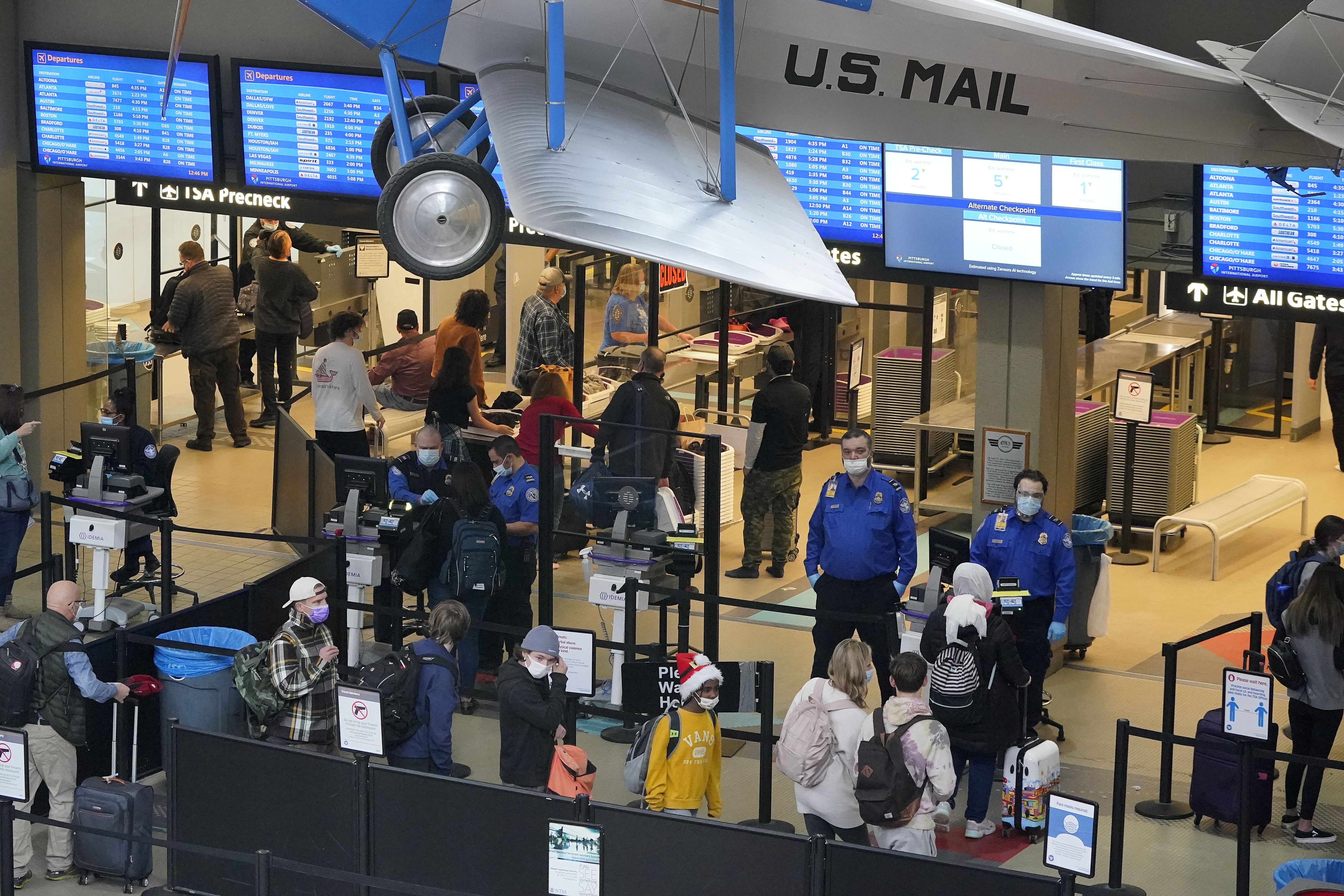 Holiday travelers line up at the security checkpoint check point at Pittsburgh International Airport in Imperial, Pa., Thursday, Dec. 23, 2021. (AP Photo/Gene J. Puskar)