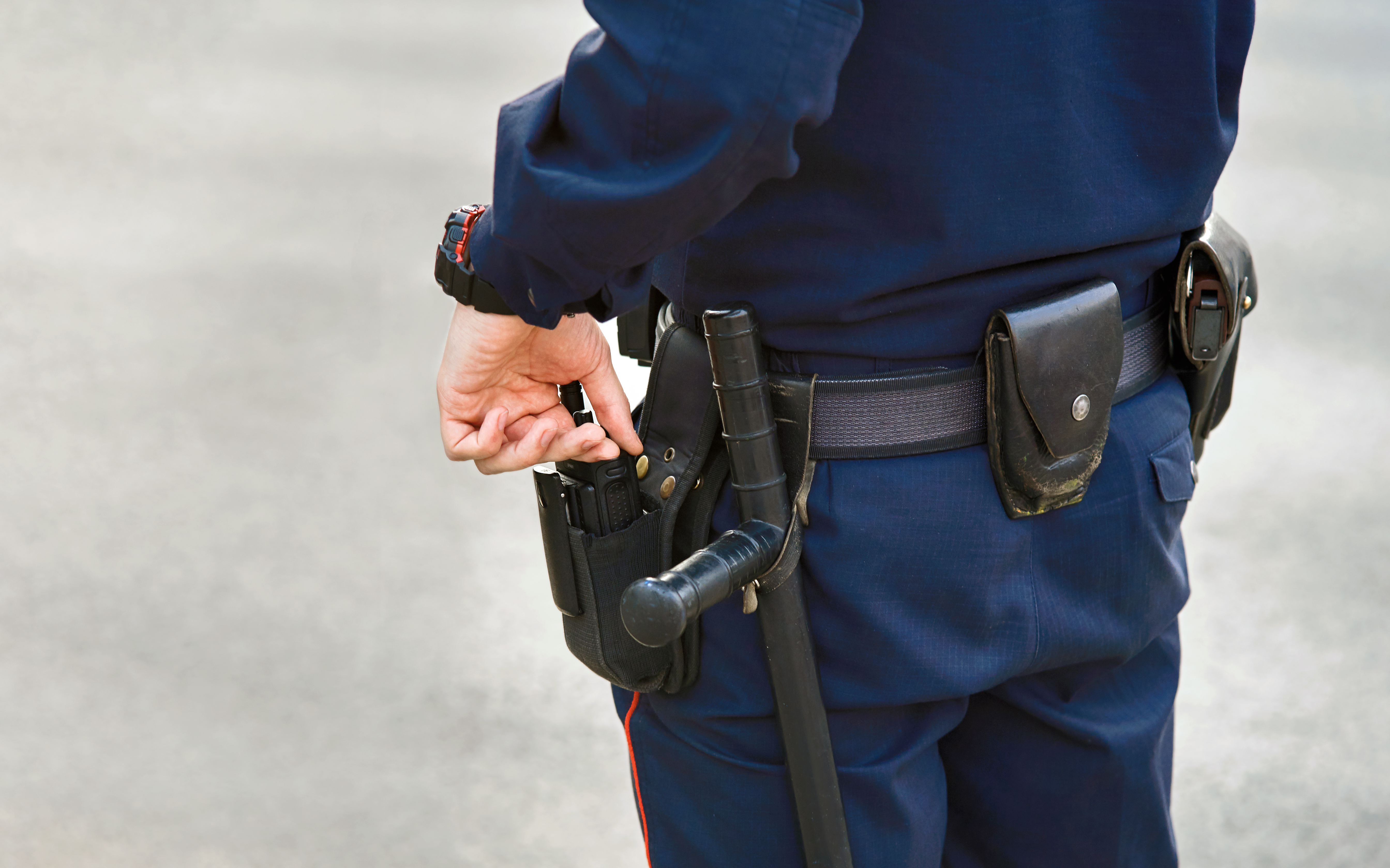 Hand,Of,Police,Officer,Holding,Radio,Set,,Baton,Tonfa,Close