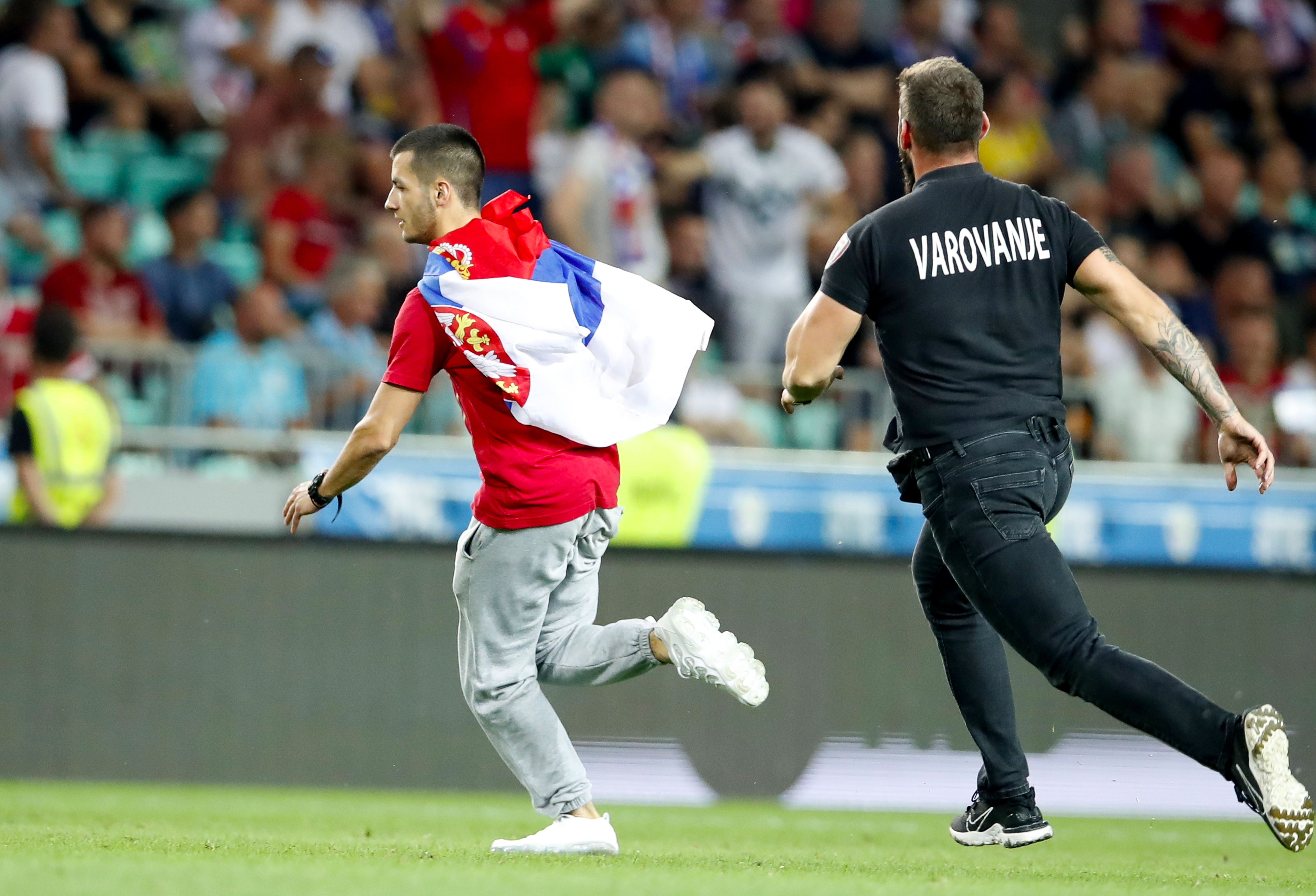 epa10010117 A pitch invader (L) is chased by security during the UEFA Nations League soccer match between Slovenia and Serbia in Ljubljana, Slovenia, 12 June 2022.  EPA-EFE/ANTONIO BAT