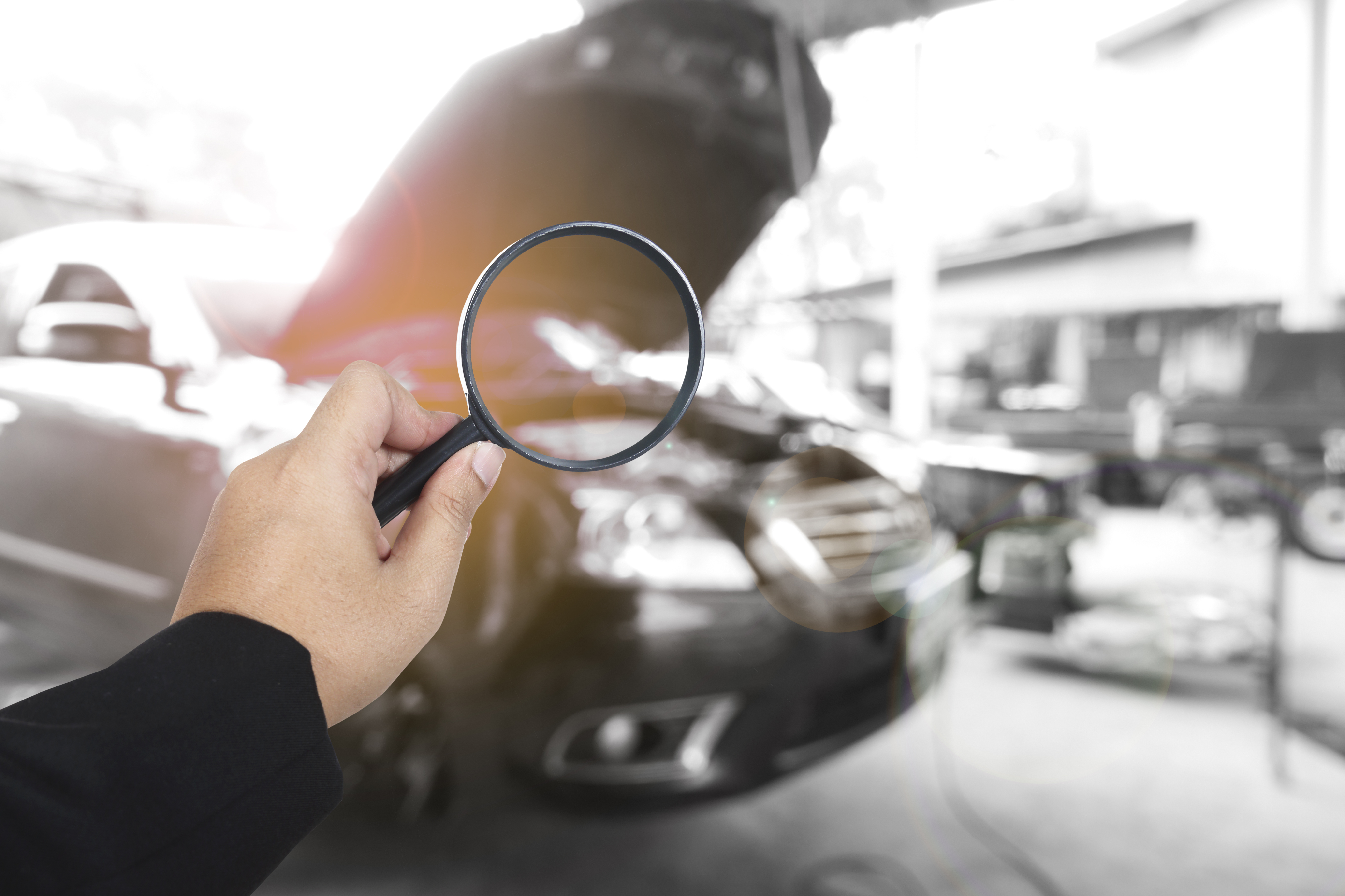 Business,Hand,Holding,Magnification,With,Car,Background