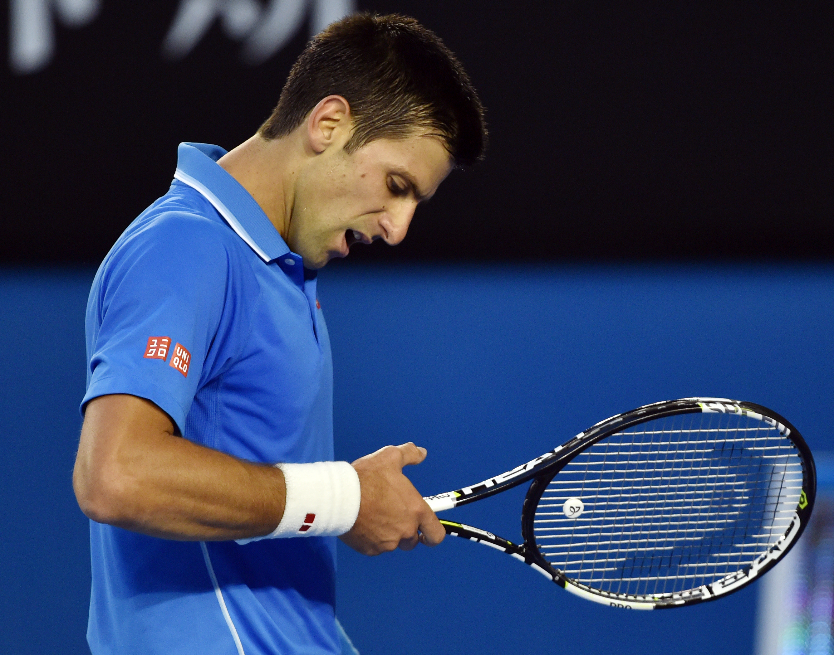epa04598380 Novak Djokovic of Serbia looks ar his injured thumb during play against Andy Murray of Britain in their men's finals match at the Australian Open Grand Slam tennis tournament in Melbourne, Australia, 01 February 2015.  EPA/Filip Singer
