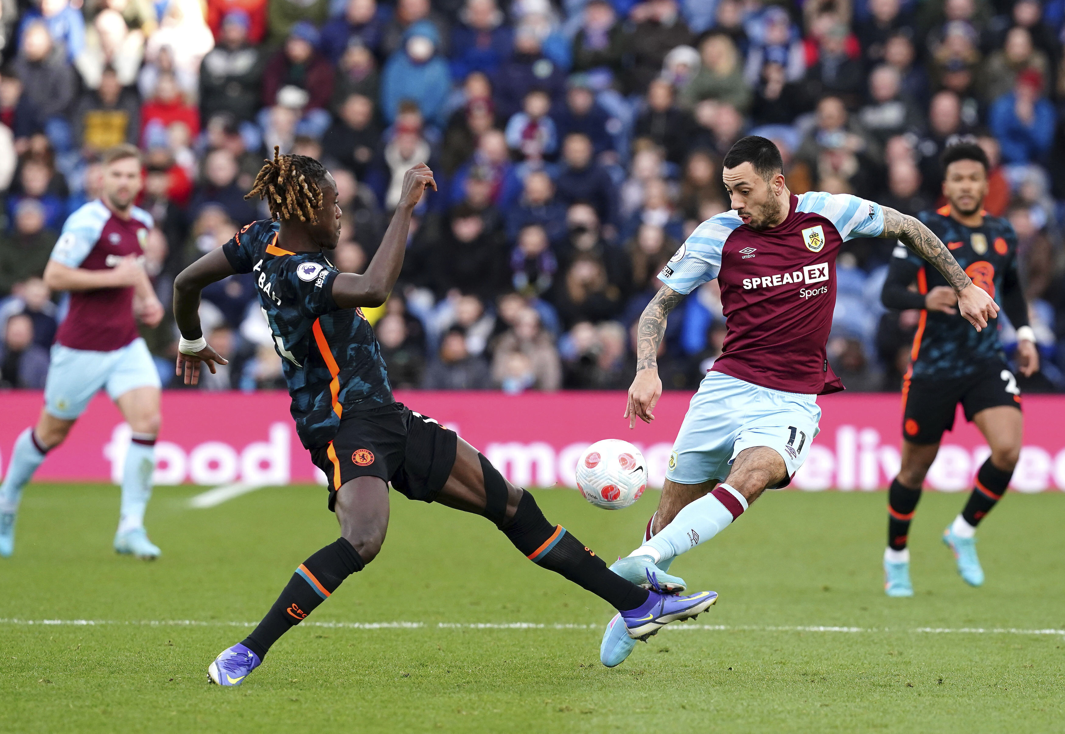 Chelsea's Trevoh Chalobah, left, and Burnley's Ashley Barnes battle for the ball during the English Premier League soccer match between Burnley and Chelsea at Turf Moor, Burnley, England, Saturday, March 5, 2022. (Martin Rickett/PA via AP)