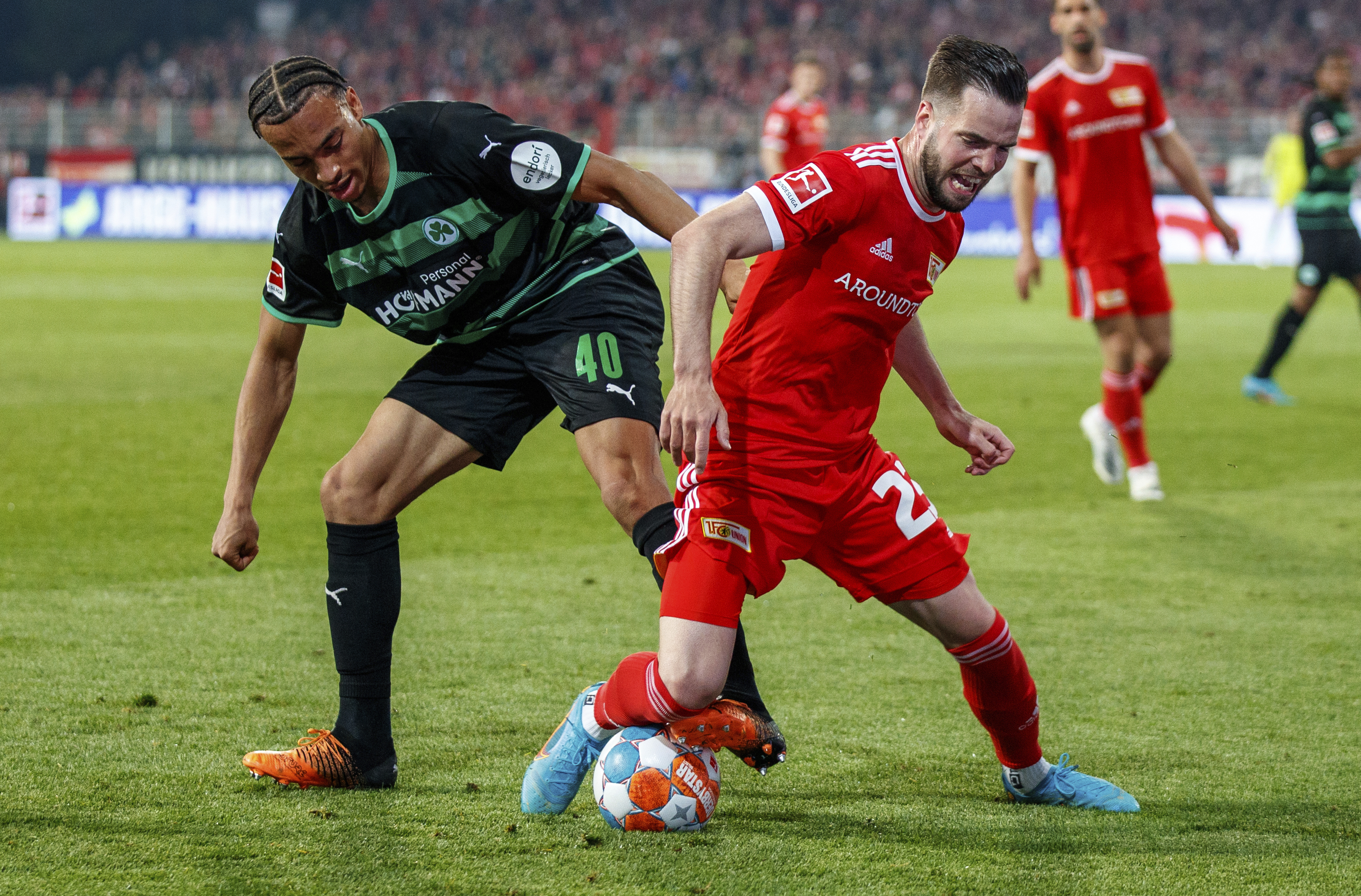 Berlin's Niko Giesselmann, right, fights for the ball with Fuerth's Jamie Leweling during the German Bundesliga soccer match between 1. FC Union Berlin and SpVgg Greuther Fuerth in Berlin, Friday, April 29, 2022. (Andreas Gora/dpa via AP)