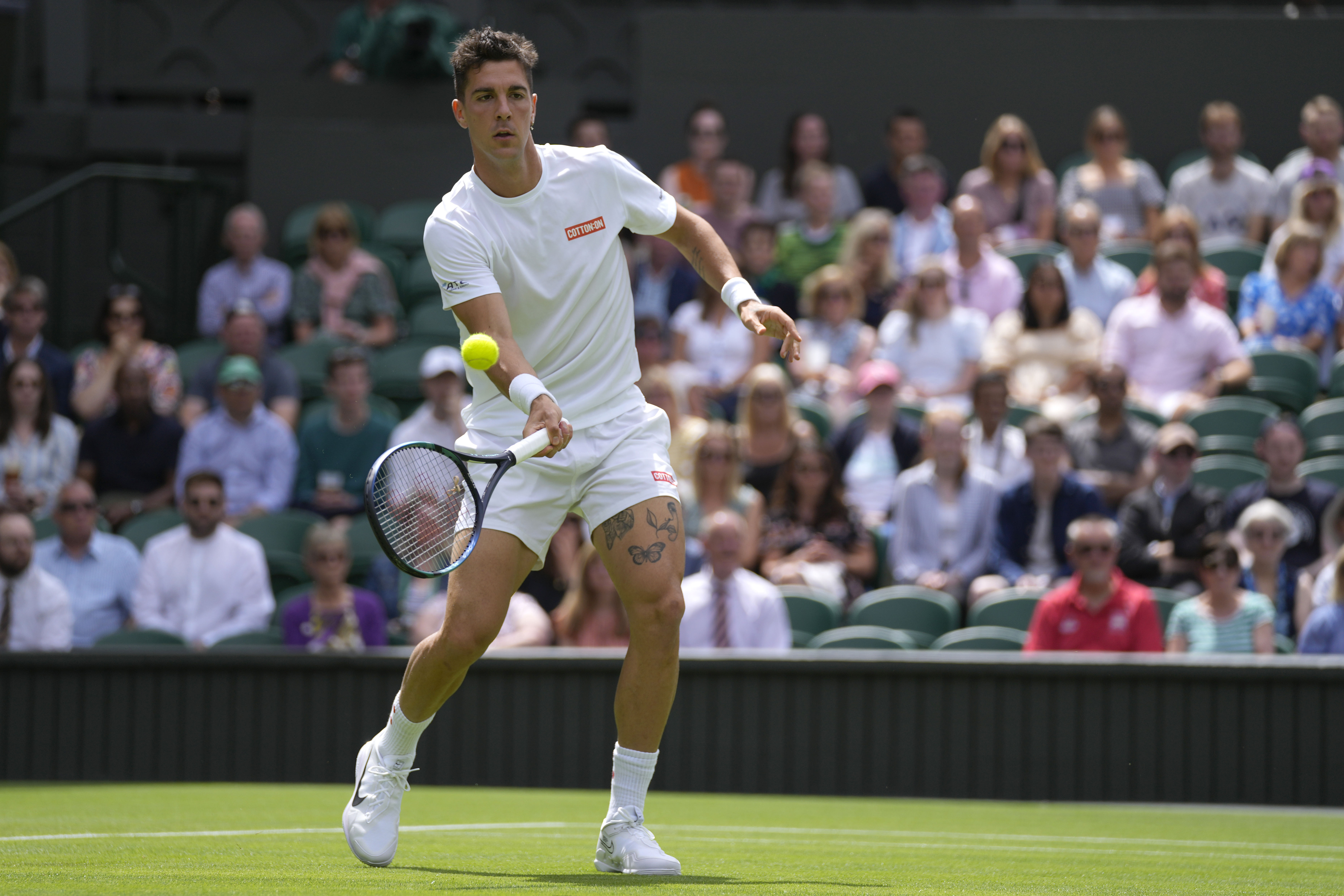 Australia's Thanasi Kokkinakis returns the ball to Serbia's Novak Djokovic during their singles tennis match on day three of the Wimbledon tennis championships in London, Wednesday, June 29, 2022. (AP Photo/Alastair Grant)