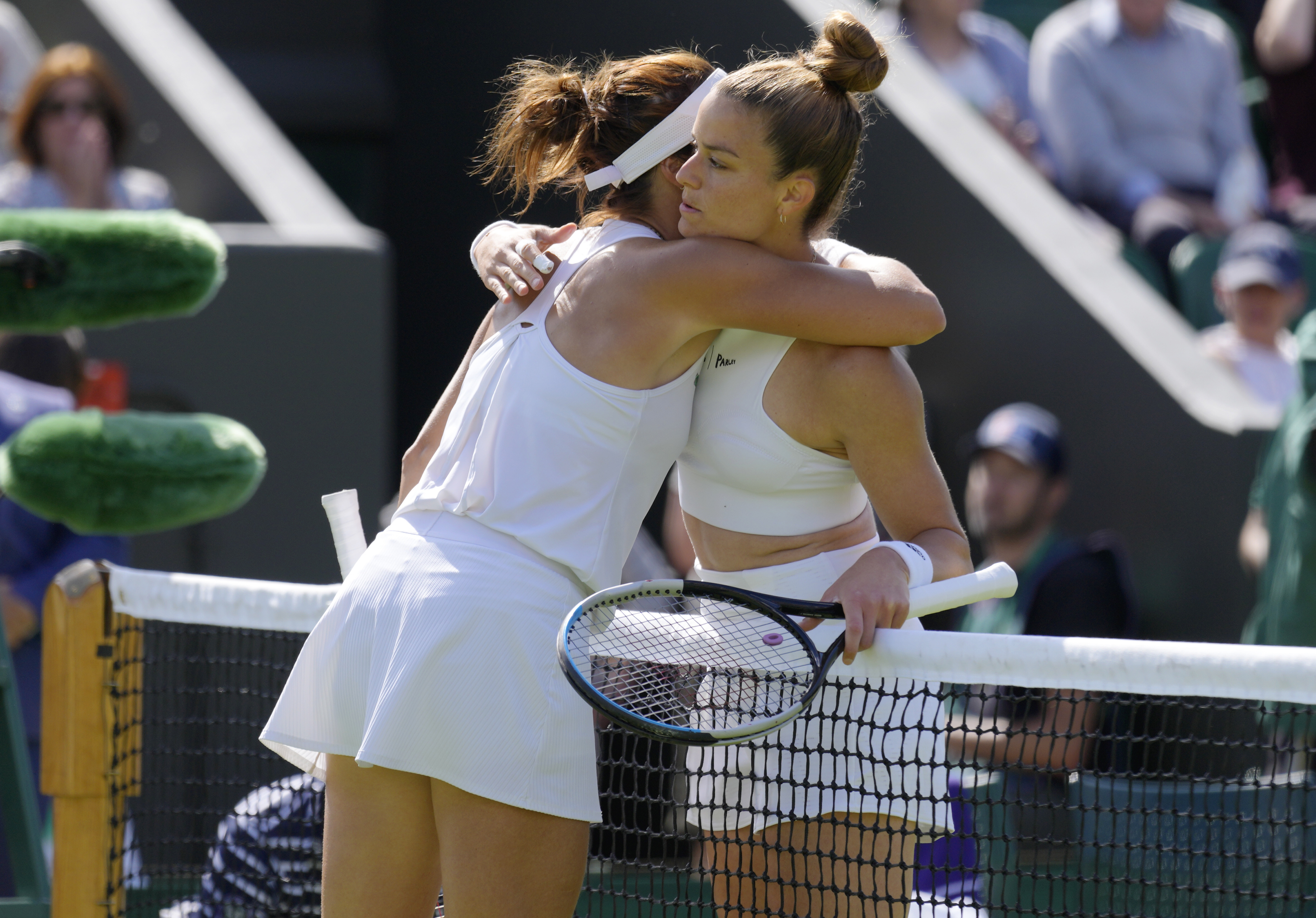 Germany's Tatjana Maria, left, embraces Greece's Maria Sakkari after beating her in their women's third round singles match on day five of the Wimbledon tennis championships in London, Friday, July 1, 2022. (AP Photo/Kirsty Wigglesworth)