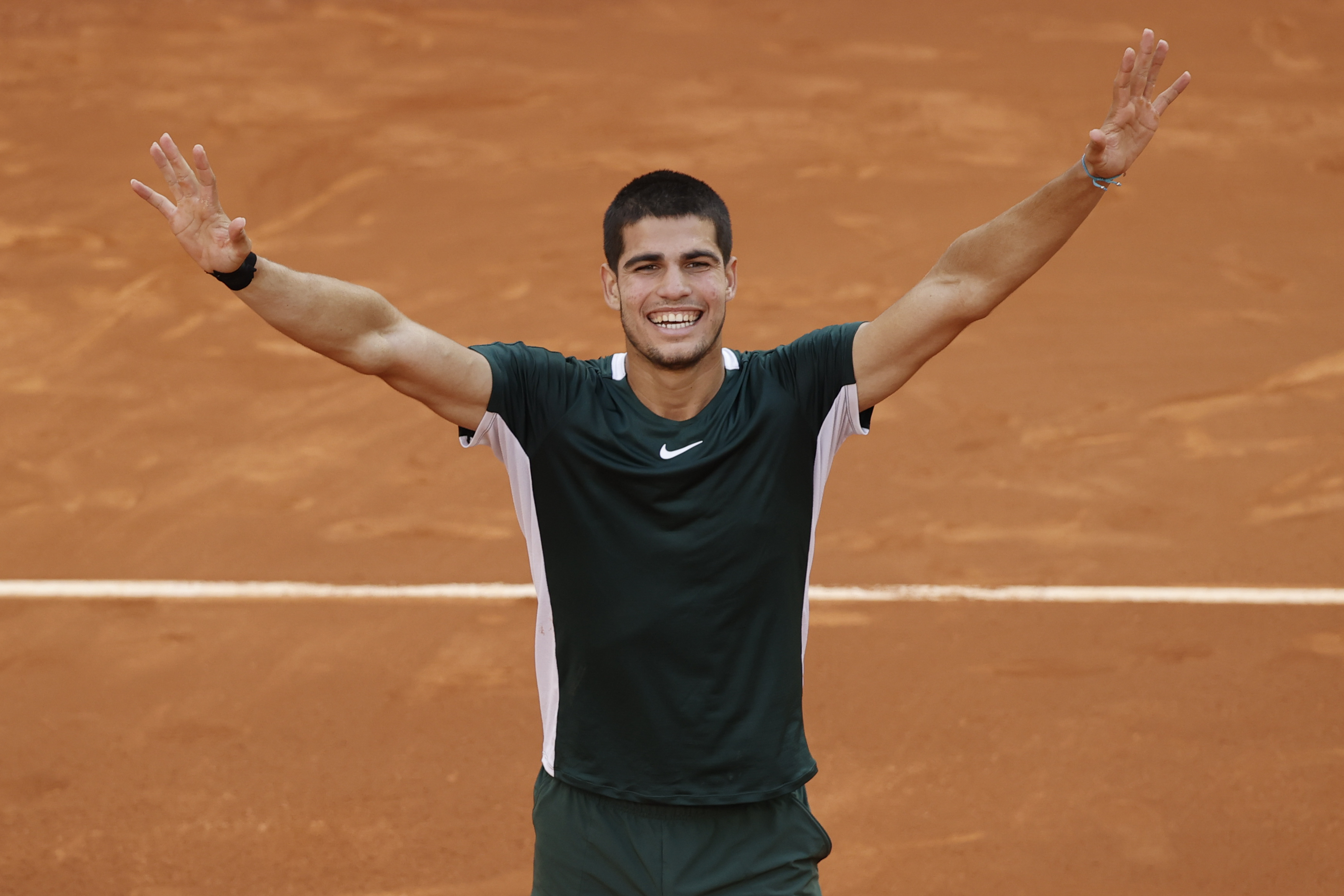 epa09932168 Carlos Alcaraz of Spain celebrates winning against Novak Djokovic of Serbia during their Mutua Madrid Open tennis tournament's semifinal match at Caja Magica sport complex in Madrid, Spain, 07 May 2022.  EPA-EFE/JUANJO MARTIN