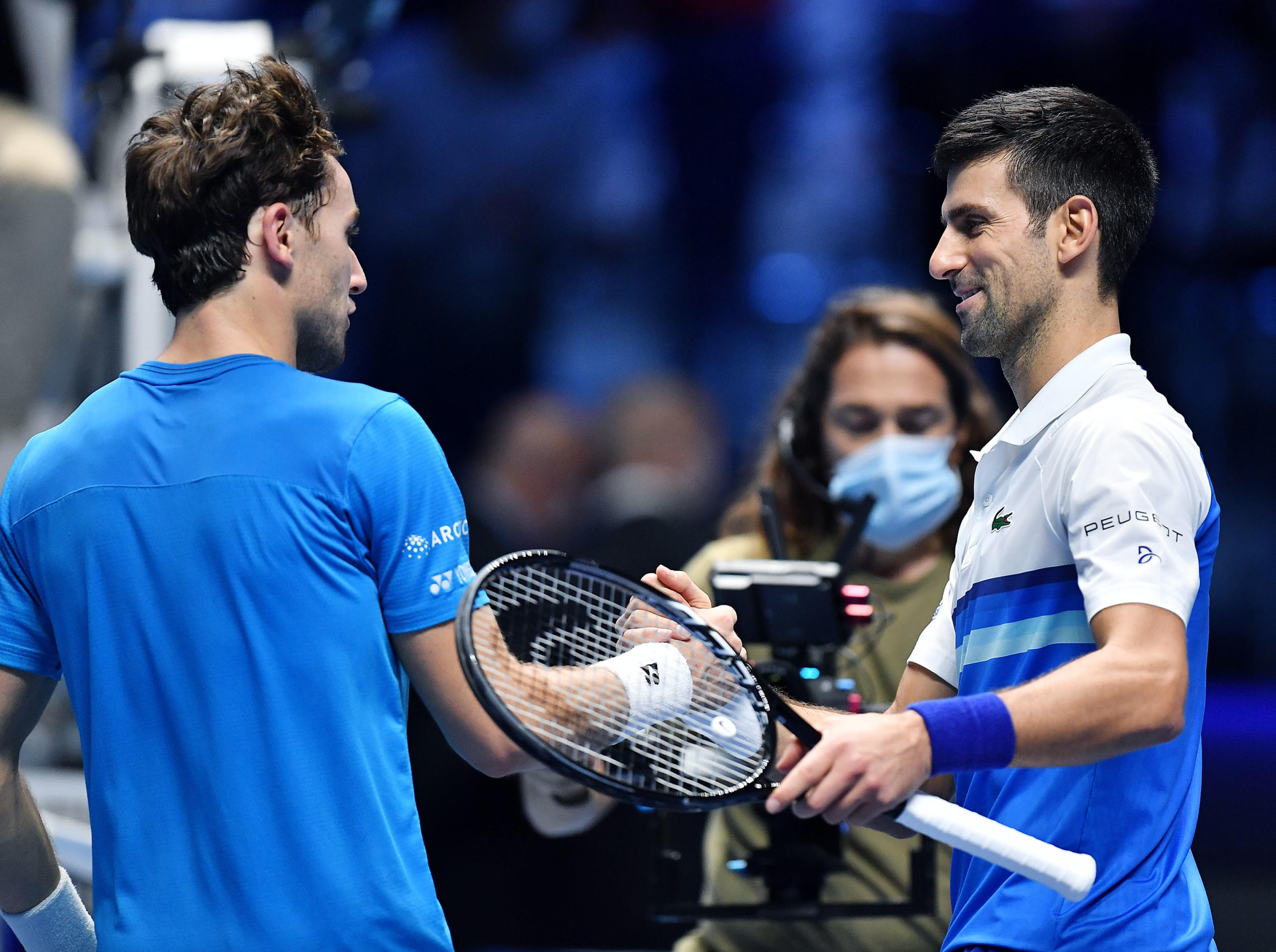 epa09583649 Novak Djokovic (R) of Serbia is congratulated by Casper Ruud (L) of Norway after winning their group stage match of the Nitto ATP Finals tennis tournament in Turin, Italy, 15 November 2021.  EPA-EFE/Alessandro Di Marco