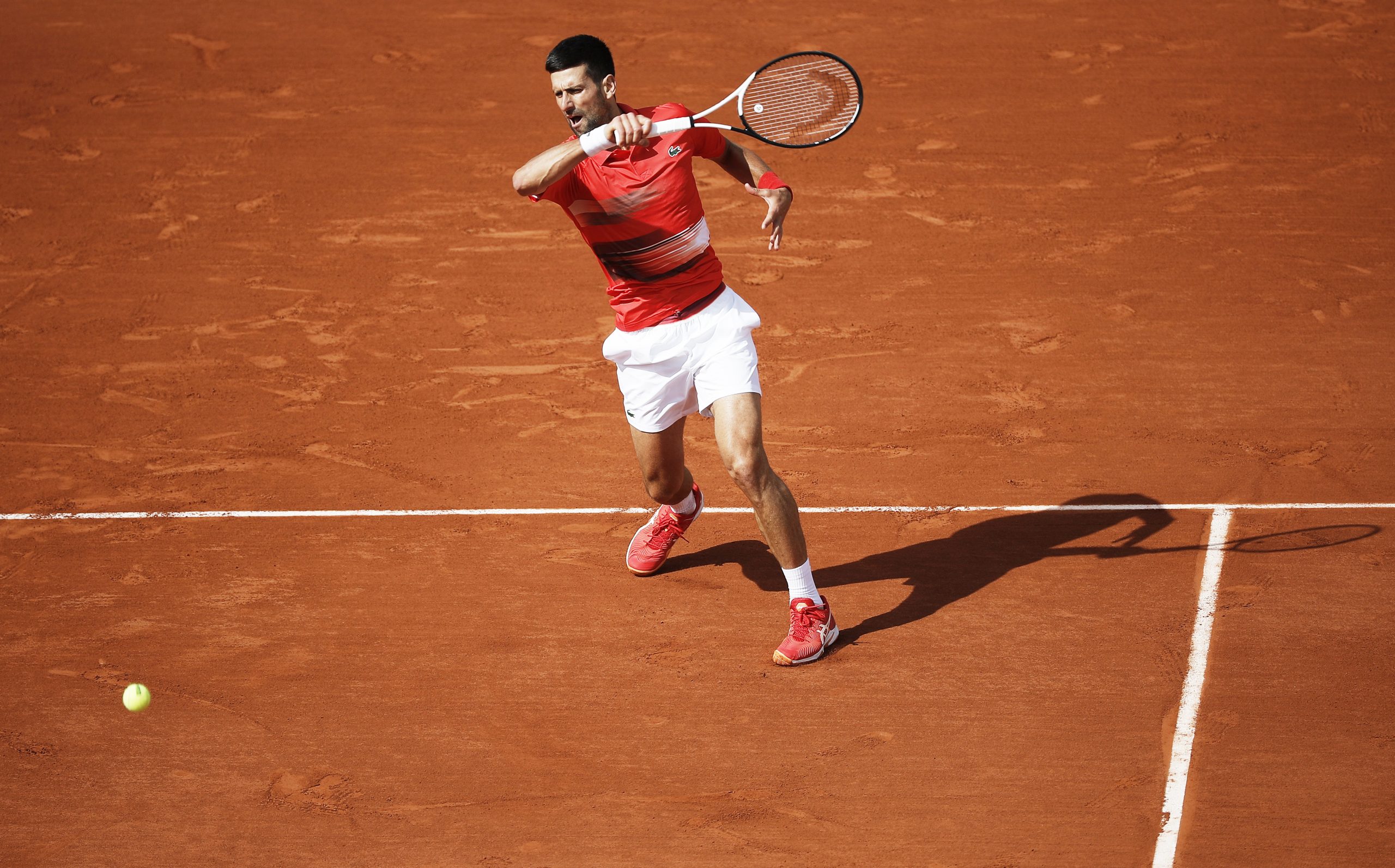 epa09974873 Novak Djokovic of Serbia hits a forehand in the men's second round match against Alex Molcan of Slovakia during the French Open tennis tournament at Roland Garros in Paris, France, 25 May 2022.  EPA-EFE/CHRISTOPHE PETIT TESSON