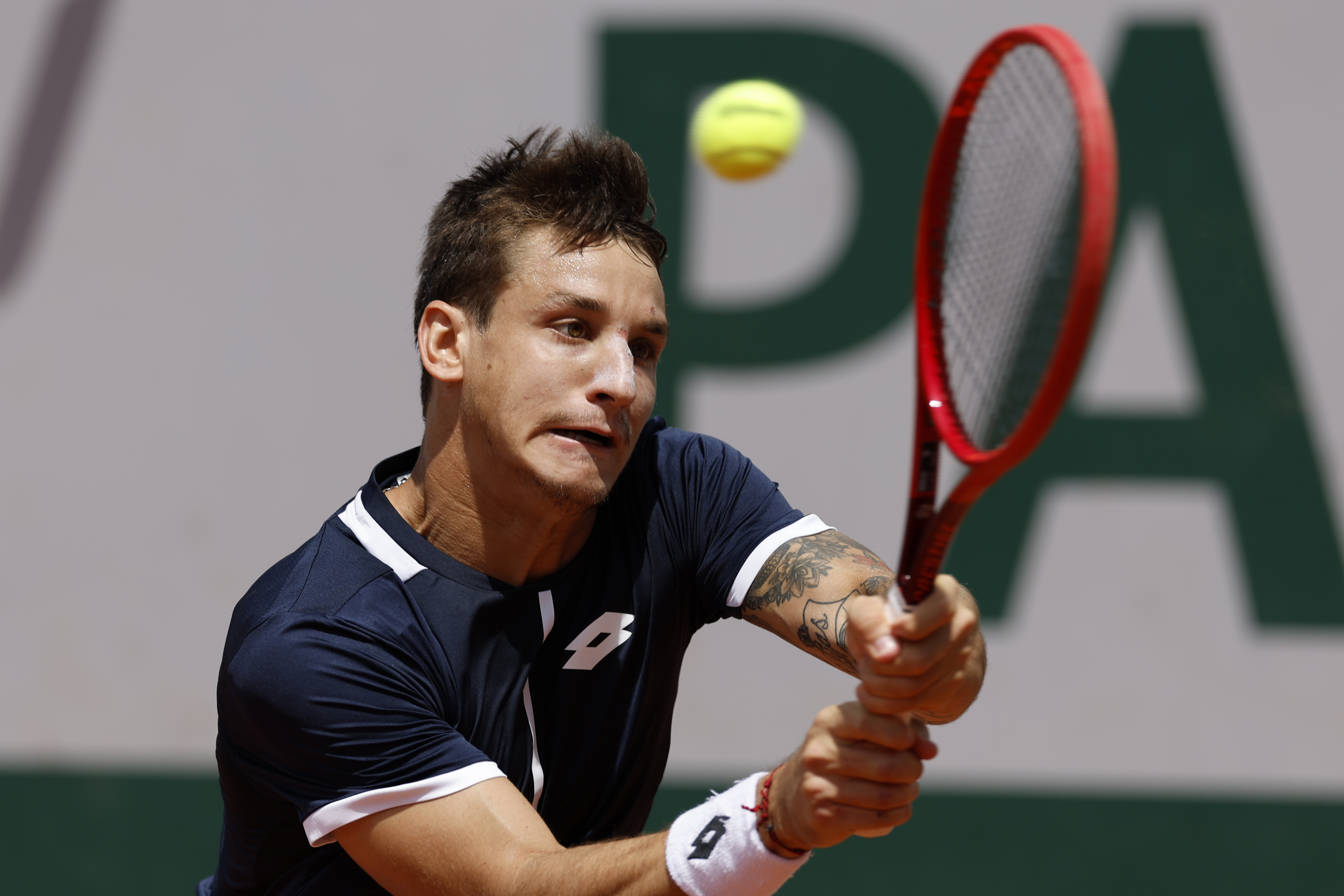 Argentina's Camilo Ugo Carabelli returns the ball to Canada's Felix Auger-Aliassime during their second round match of the French Open tennis tournament at the Roland Garros stadium Wednesday, May 25, 2022 in Paris. (AP Photo/Jean-Francois Badias)