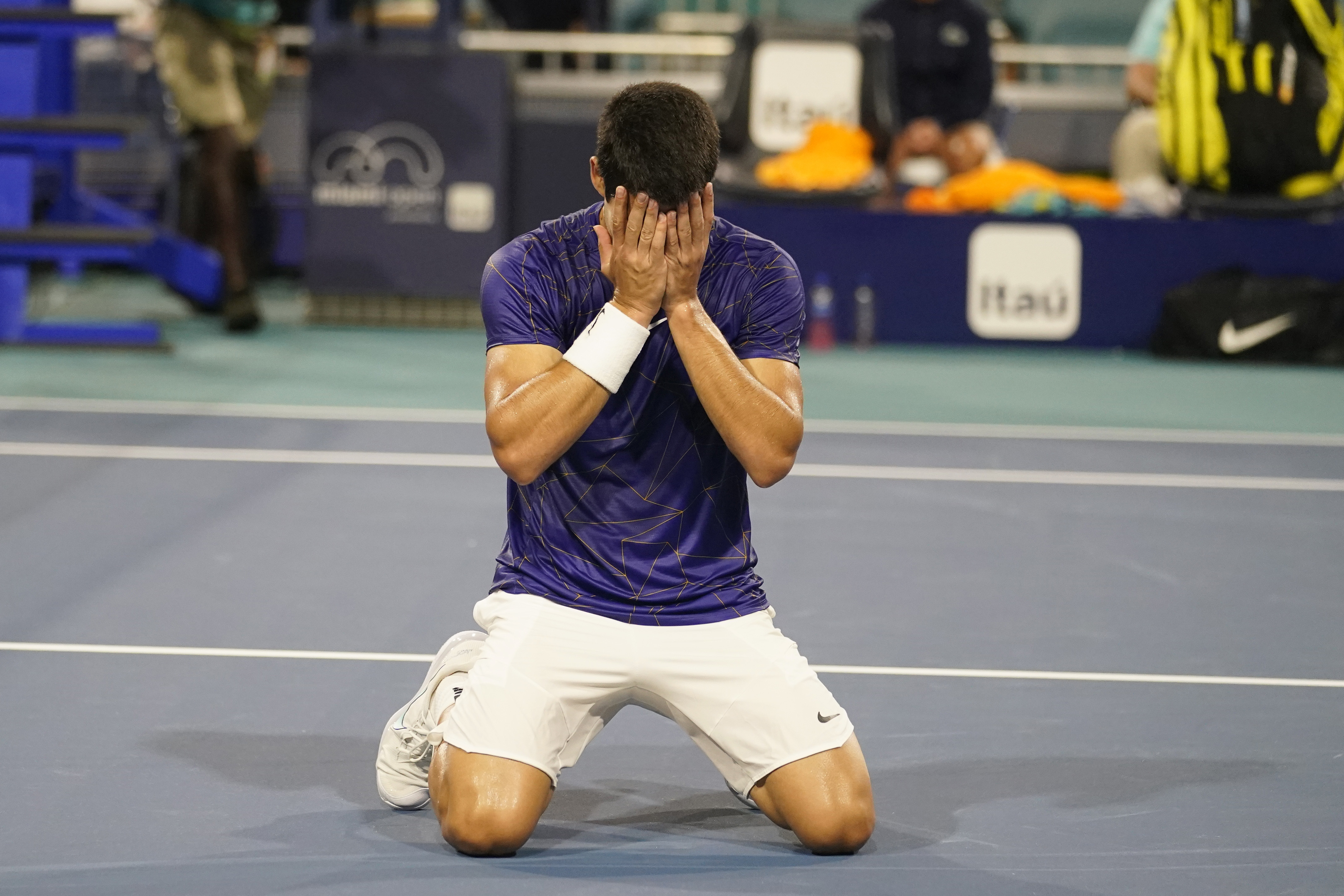Carlos Alcaraz, of Spain, kneels on the court after defeating Miomir Kecmanovic, of Serbia, during the Miami Open tennis tournament, Thursday, March 31, 2022, in Miami Gardens, Fla. (AP Photo/Marta Lavandier)