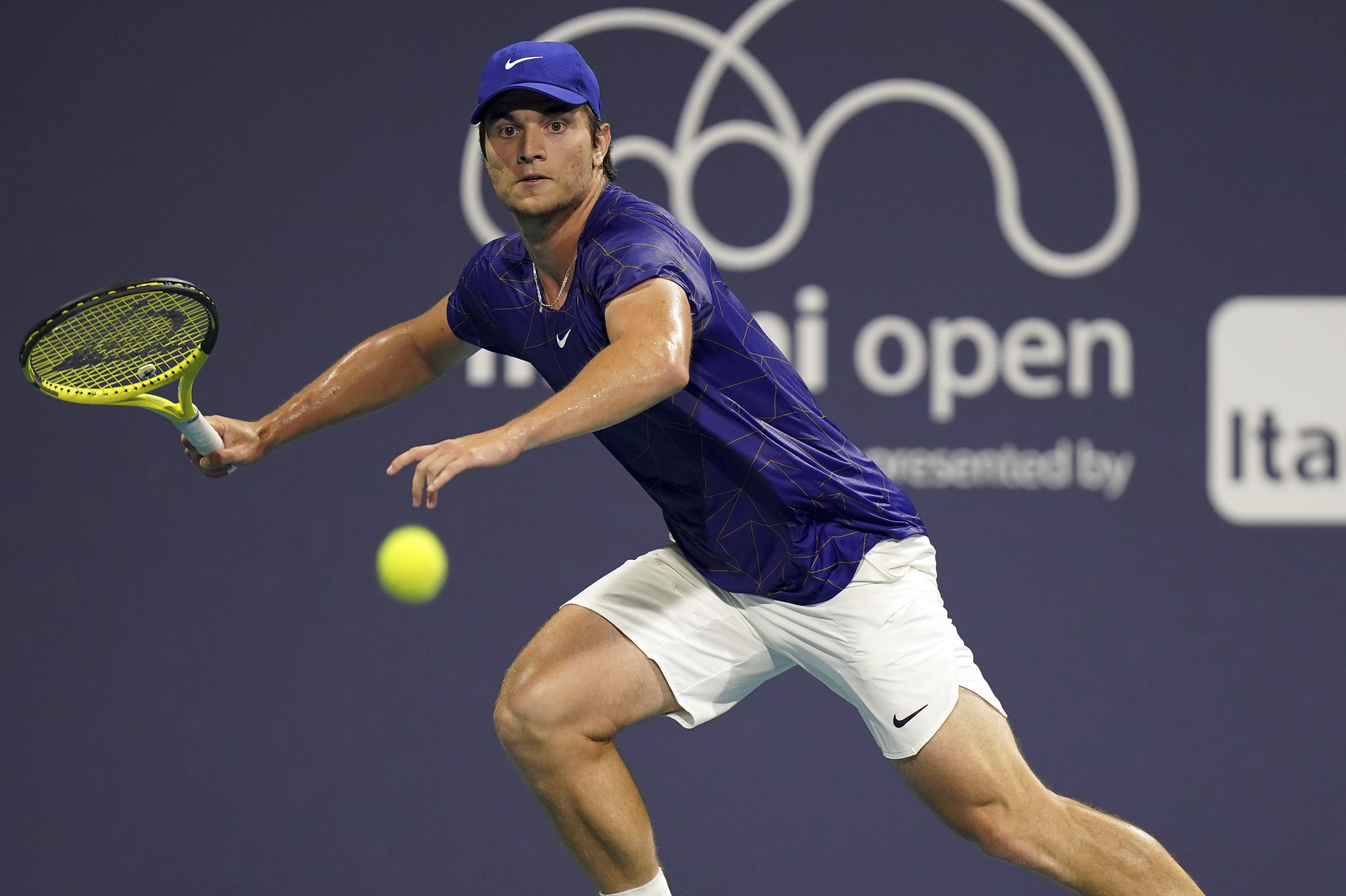 Miomir Kecmanovic, of Serbia, runs down a volley against Sebastian Korda, of the United States, during the Miami Open tennis tournament, Monday, March 28, 2022, in Miami Gardens, Fla. (AP Photo/Jim Rassol)